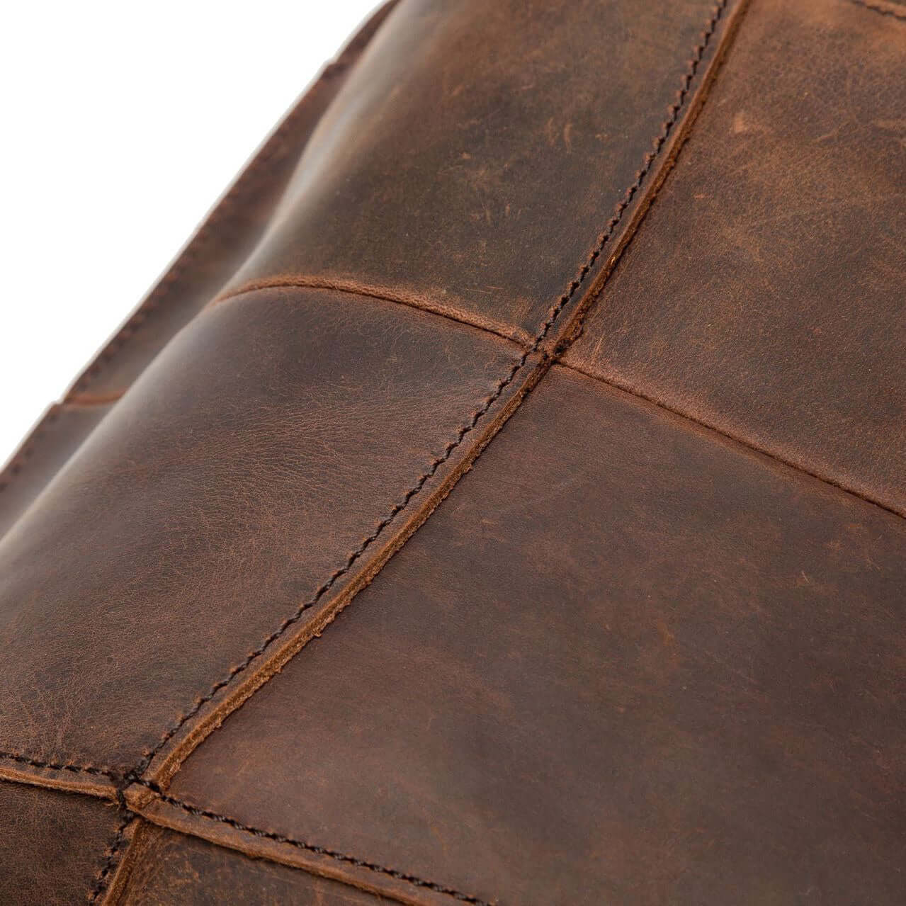 Close-up of a vintage natural leather backpack showcasing rich textures and stitching details.