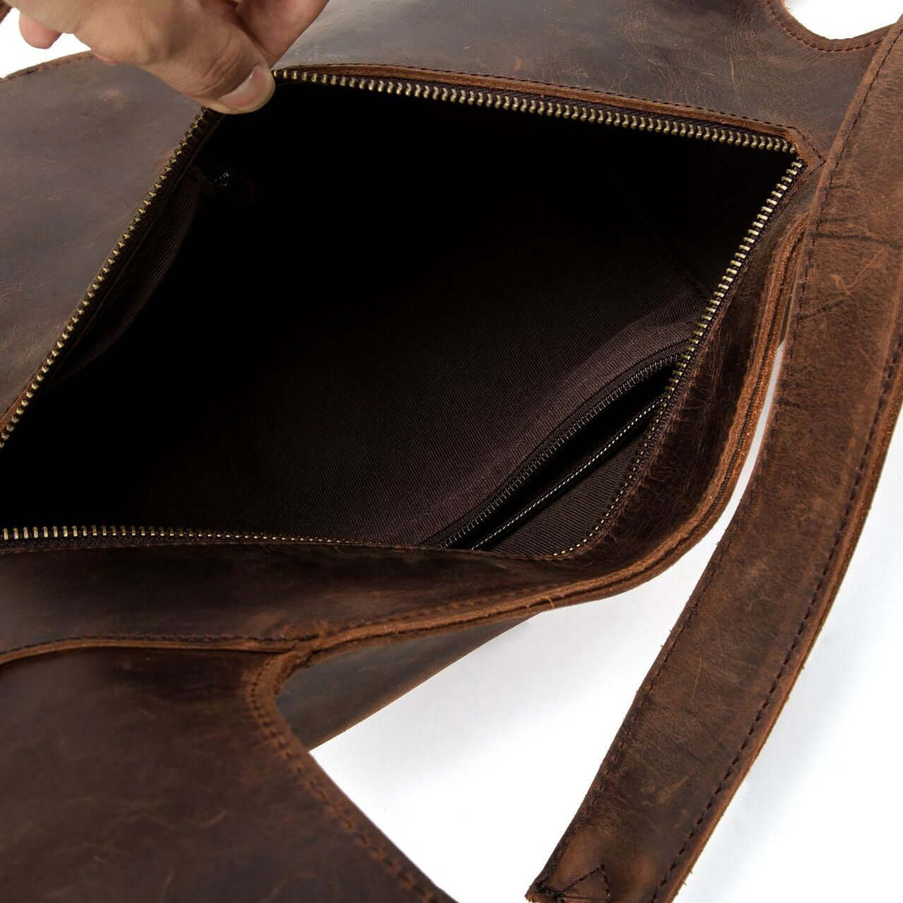 Interior view of a natural leather backpack showing zipper compartments for secure storage.