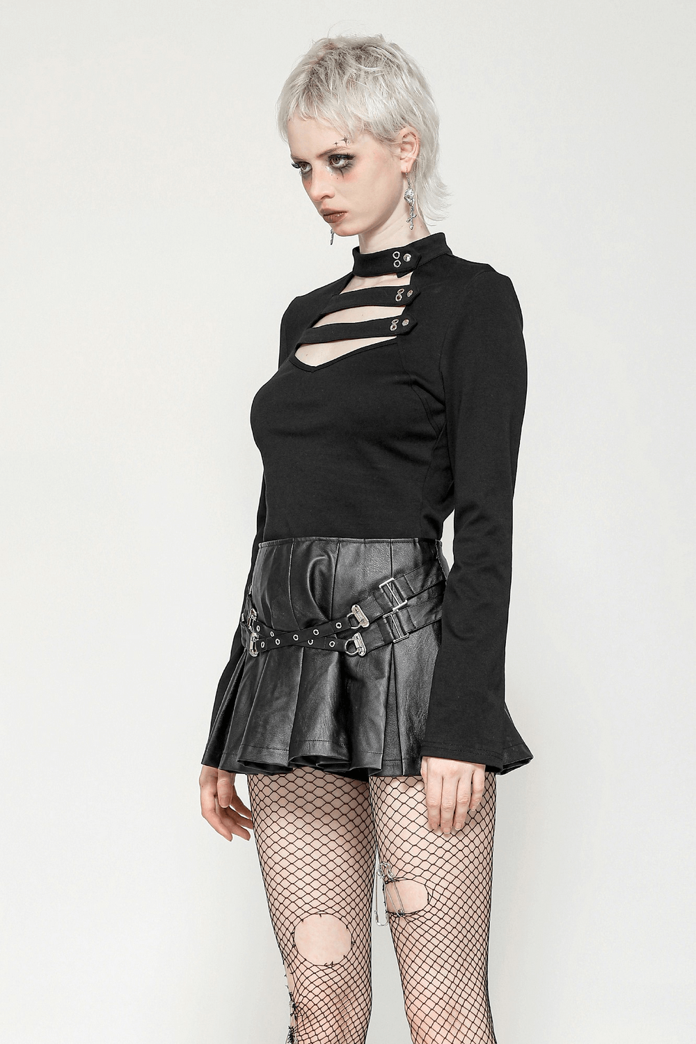 Gothic long sleeve top with neck cutout and button detail, paired with a leather skirt and fishnet tights.