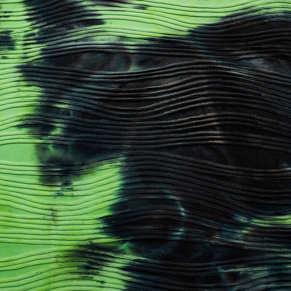 Close-up of neon green and black tie-dye fabric with wavy texture, perfect for cyber fashion and alternative styles.