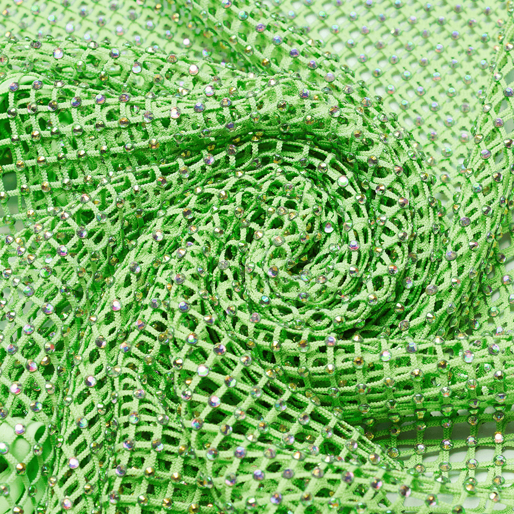 Close-up of elastic green rhinestone mesh fabric, ideal for cyberpunk fashion and edgy designs.