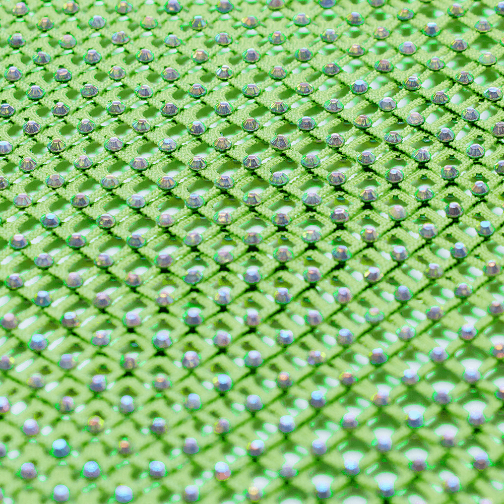 Close-up of shimmering neon green mesh fabric with rhinestones, perfect for a stylish cyberpunk bodysuit.