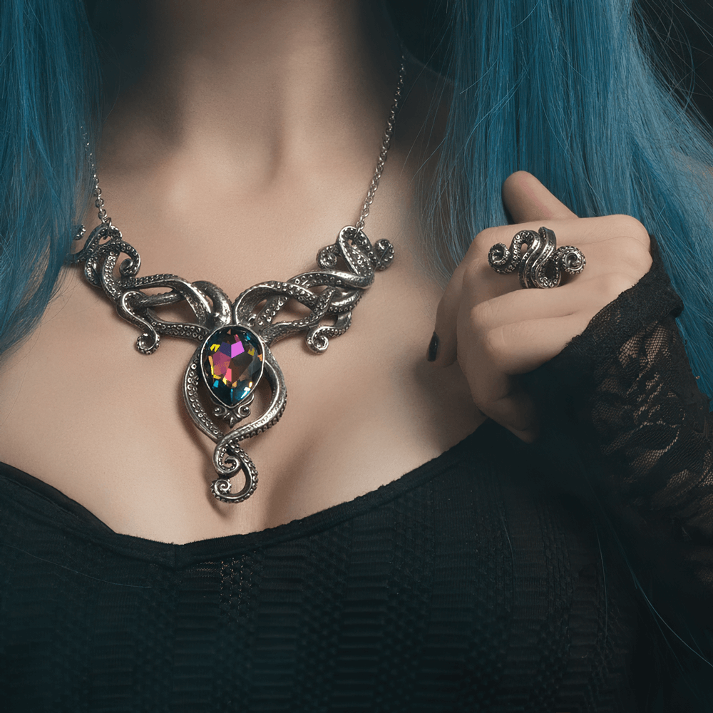 Octopus tentacle necklace featuring a rainbow crystal jewel, worn by a person with blue hair.