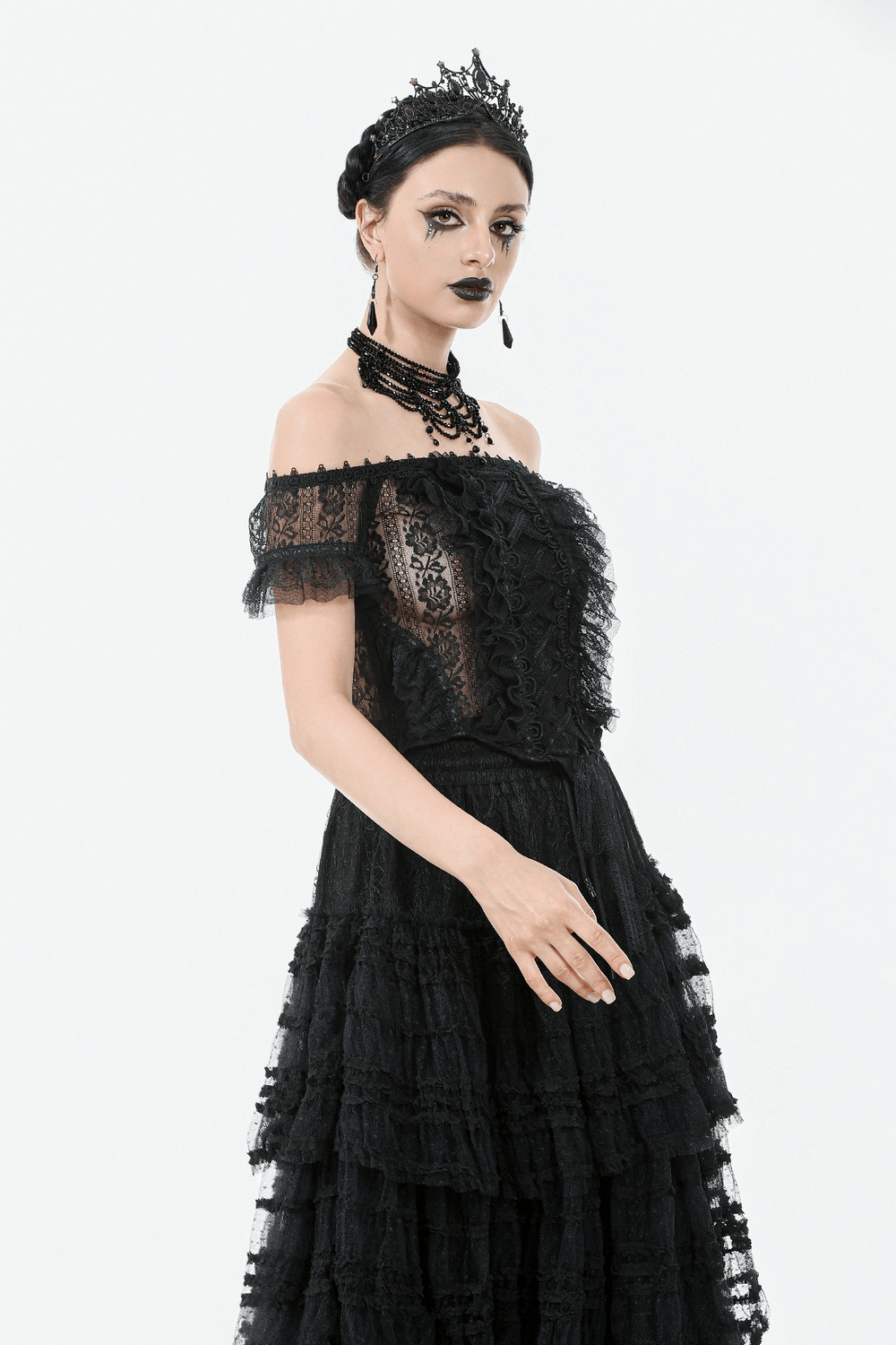 Off-shoulder lace-trimmed gothic top with ribbon details, styled with layered black skirt and gothic accessories.