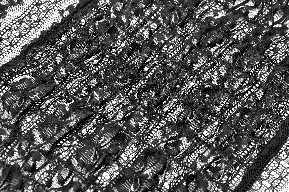 Close-up of intricate black lace fabric featuring beautiful floral patterns, perfect for gothic fashion.