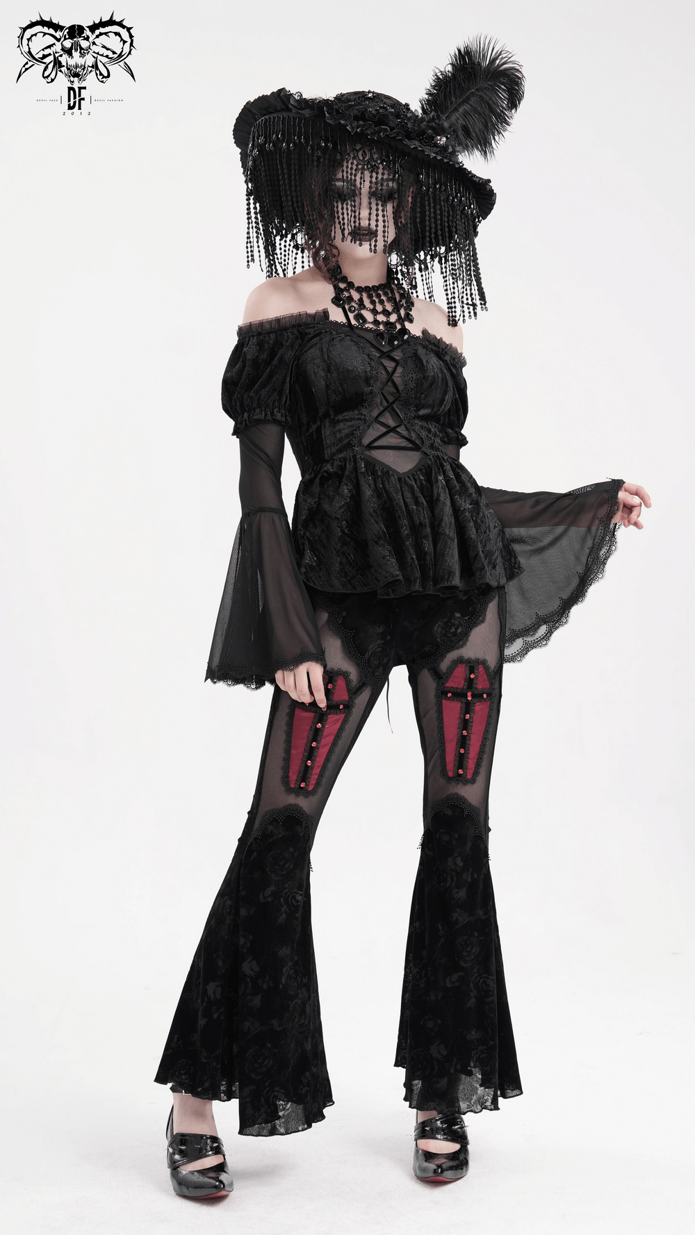 Gothic elegance in an off-shoulder velvet top with sheer sleeves and lace trim, paired with stylish black flared pants.