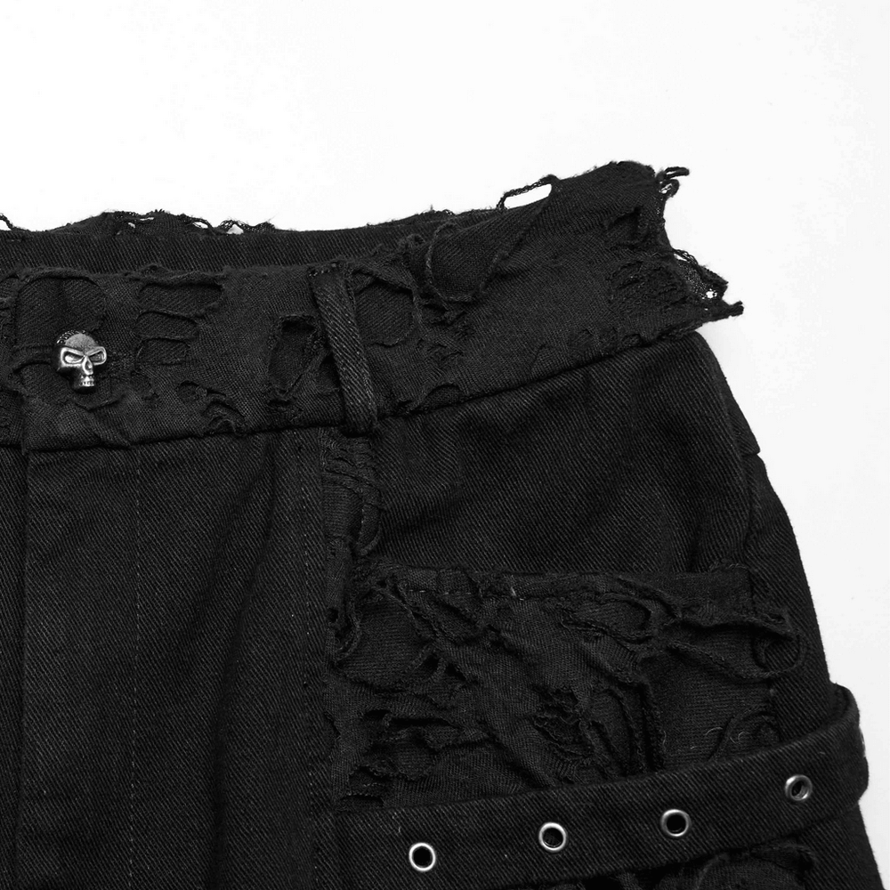 Close-up of distressed black punk pants showcasing ripped detail and edgy embellishments.