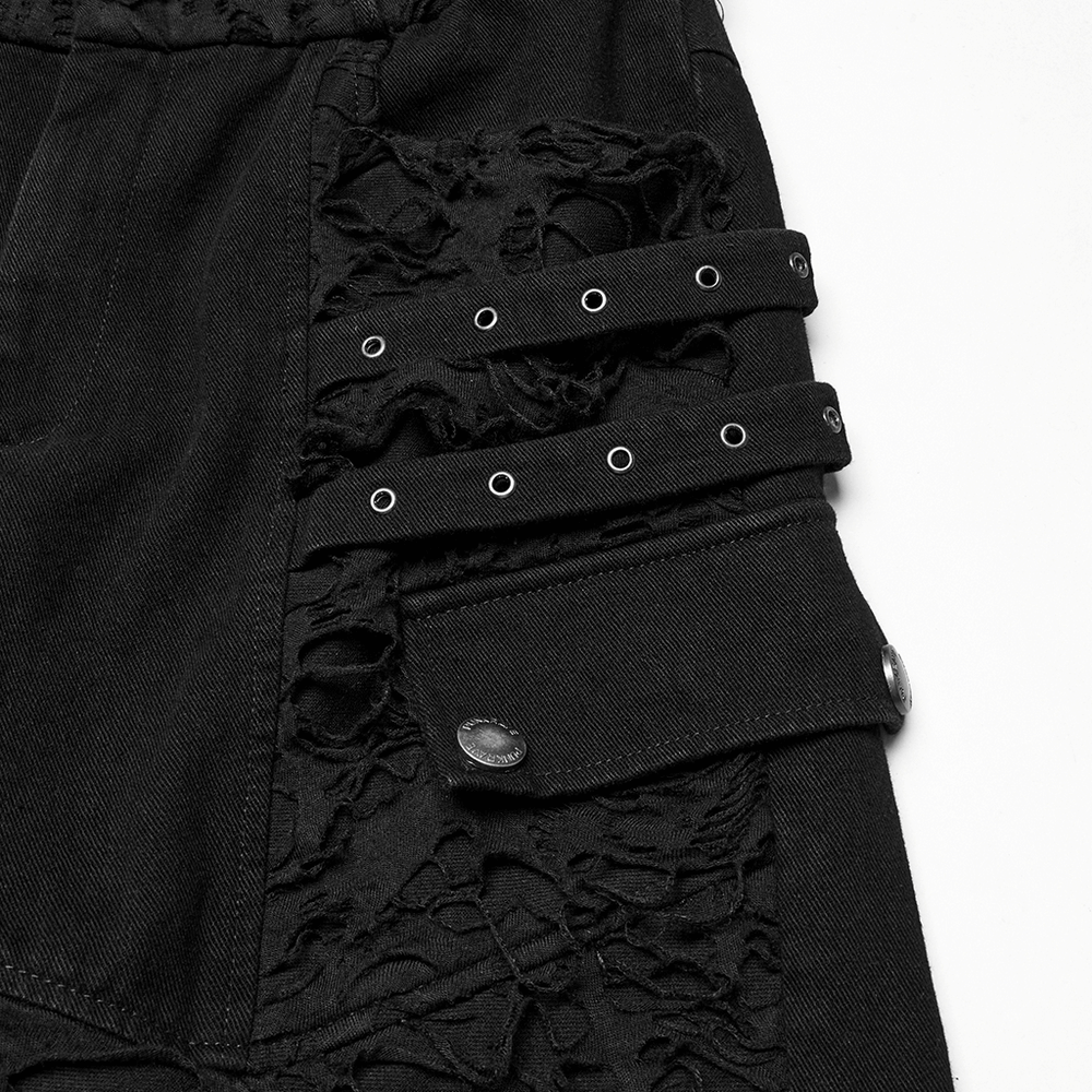 Close-up of black punk pants showcasing ripped details and studs for an edgy, rebellious style.