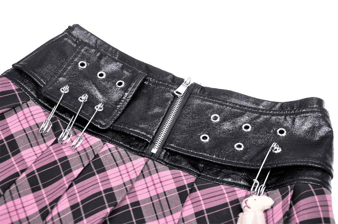 Close-up of pink and black plaid mini skirt featuring edgy leather belt and grommet details. Perfect for punk rock style!