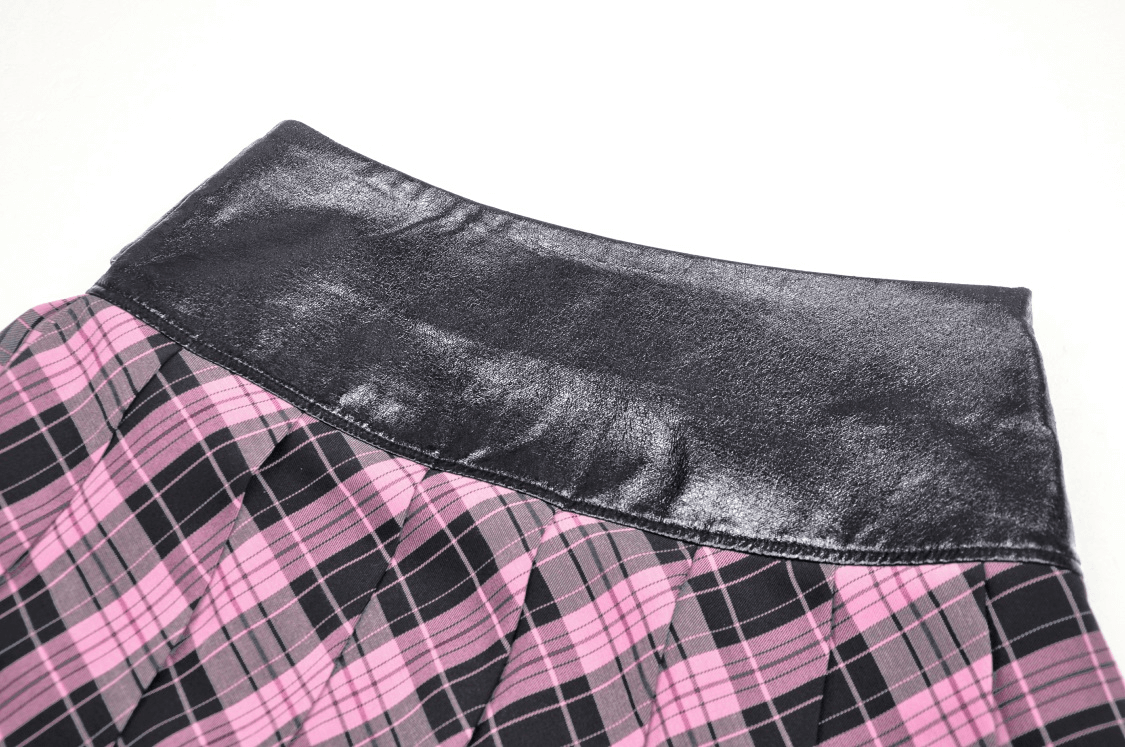 Close-up of a pink and black plaid mini skirt with a shiny black leather waistband and edgy grommet details.
