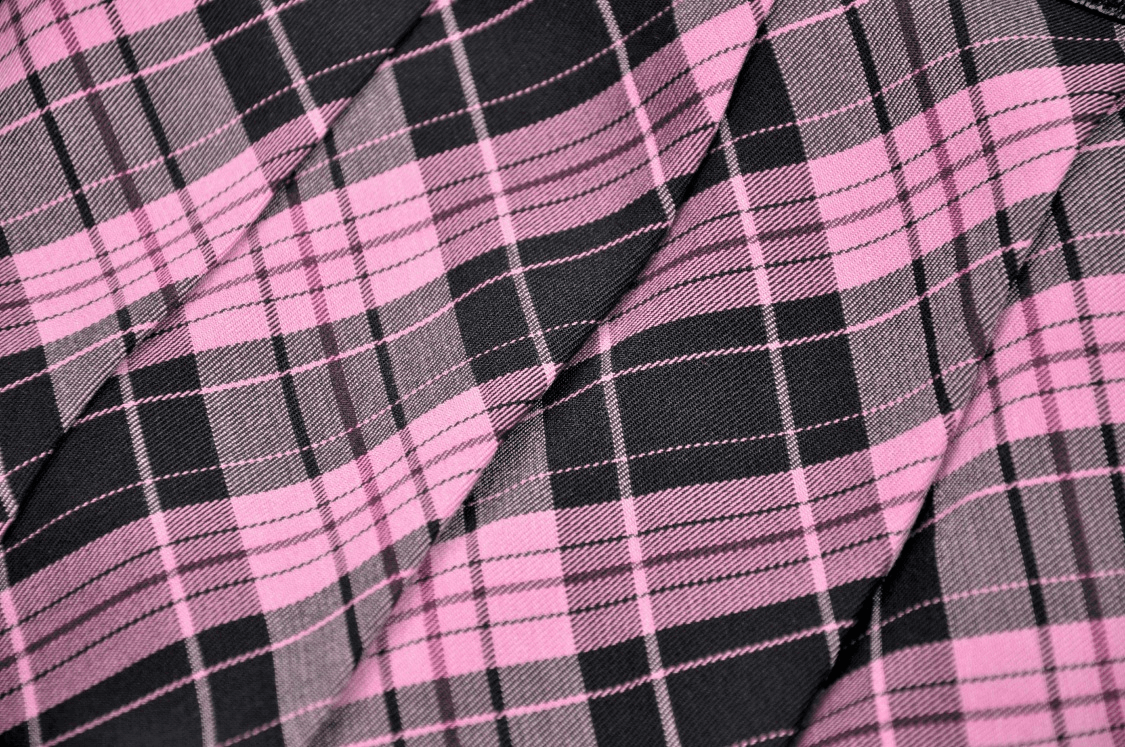 Close-up of pink and black plaid fabric, perfect for a punk rock mini skirt with edgy style.
