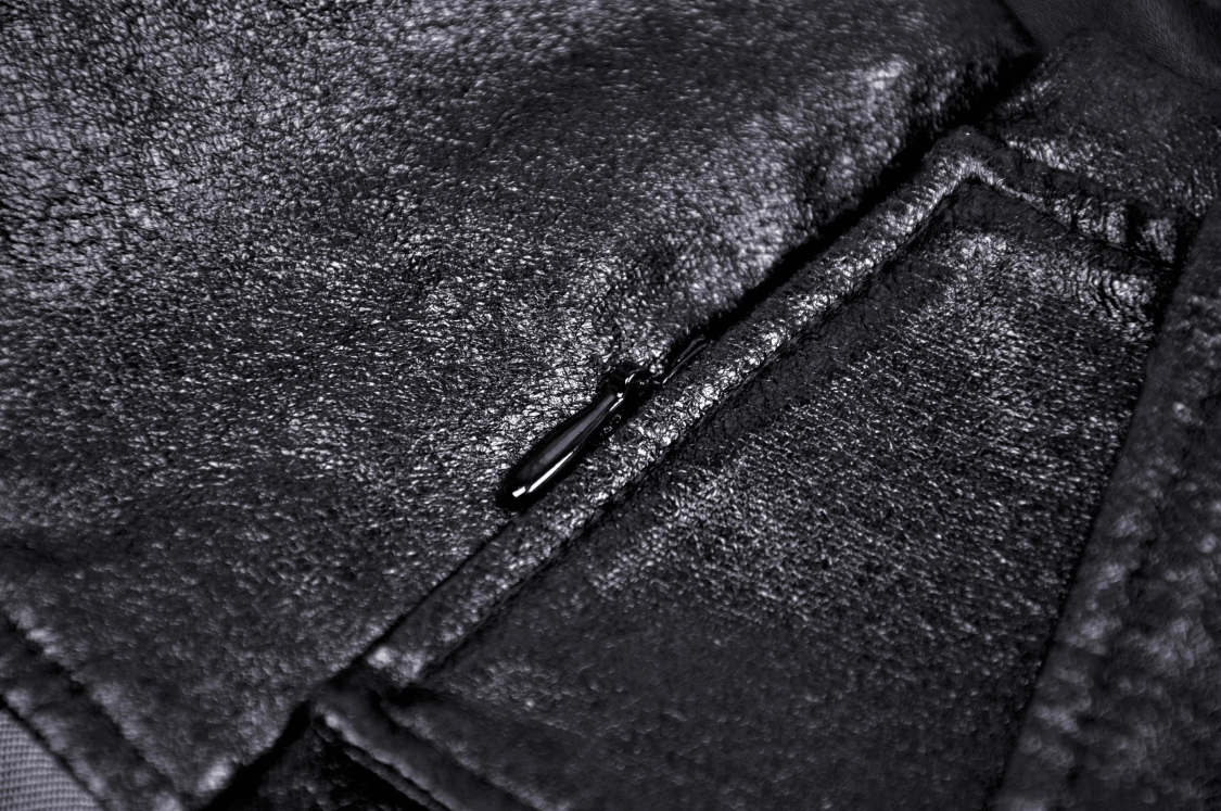 Close-up of a sleek black fabric featuring a zipper detail, showcasing modern punk rock style.