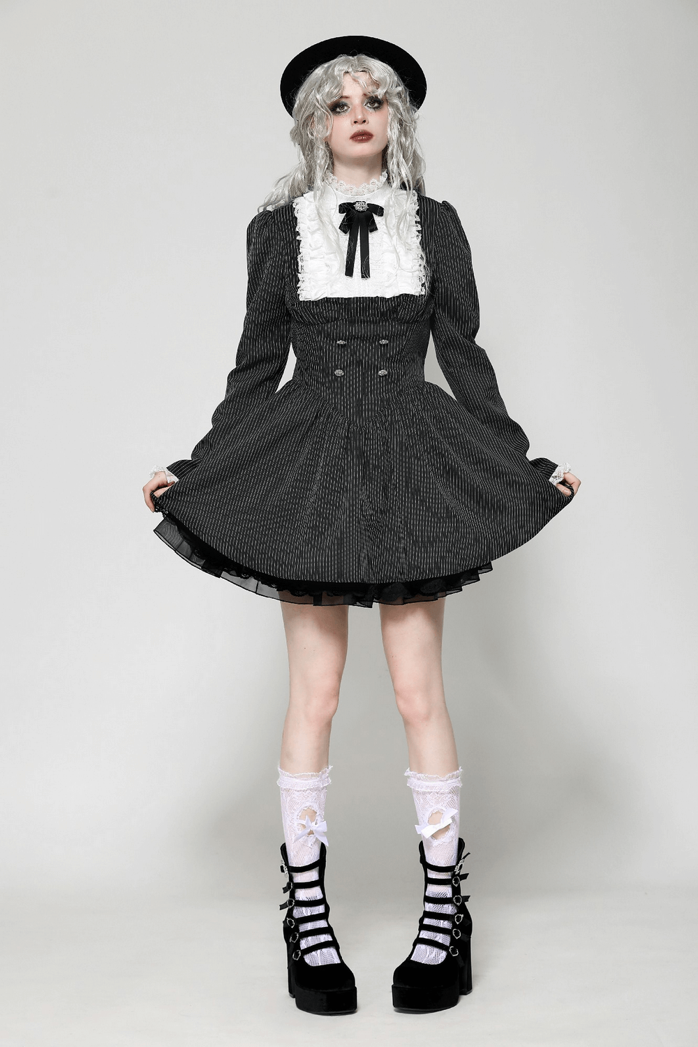 Model showcasing a stylish pinstripe gothic dress with lace ruffle bib and bow, perfect for vintage and alternative fashion.