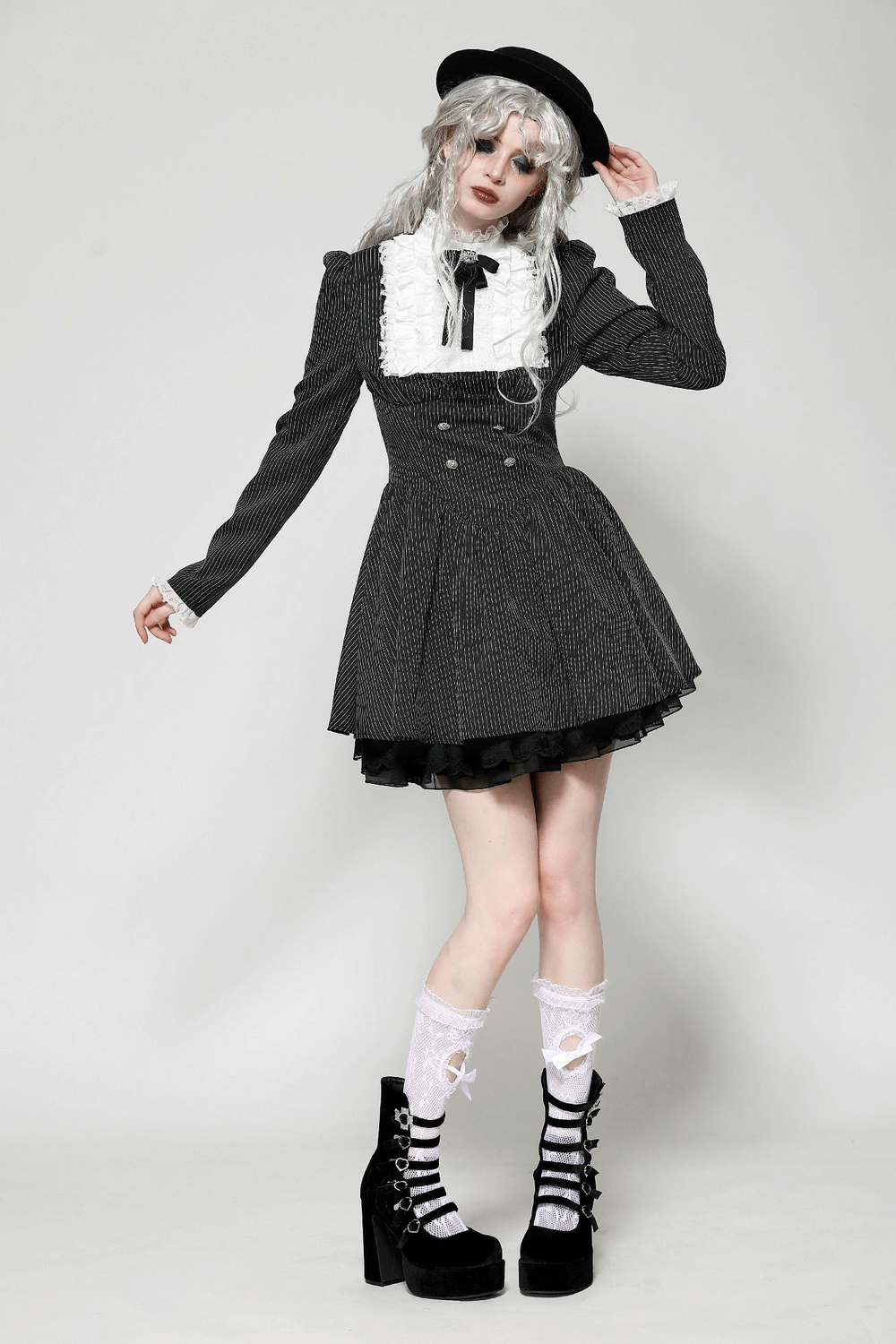 Stylish model in a pinstripe gothic dress with lace ruffle, bow details, and platform shoes, showcasing vintage elegance.