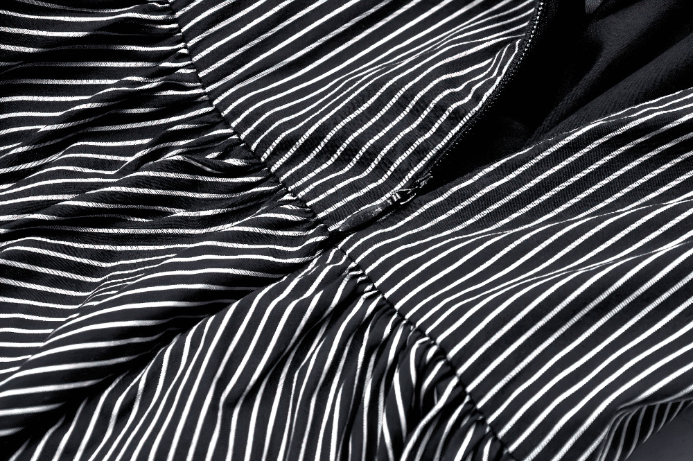 Close-up of pinstripe fabric details on a gothic dress with ruffled skirt and lace trim for vintage style.