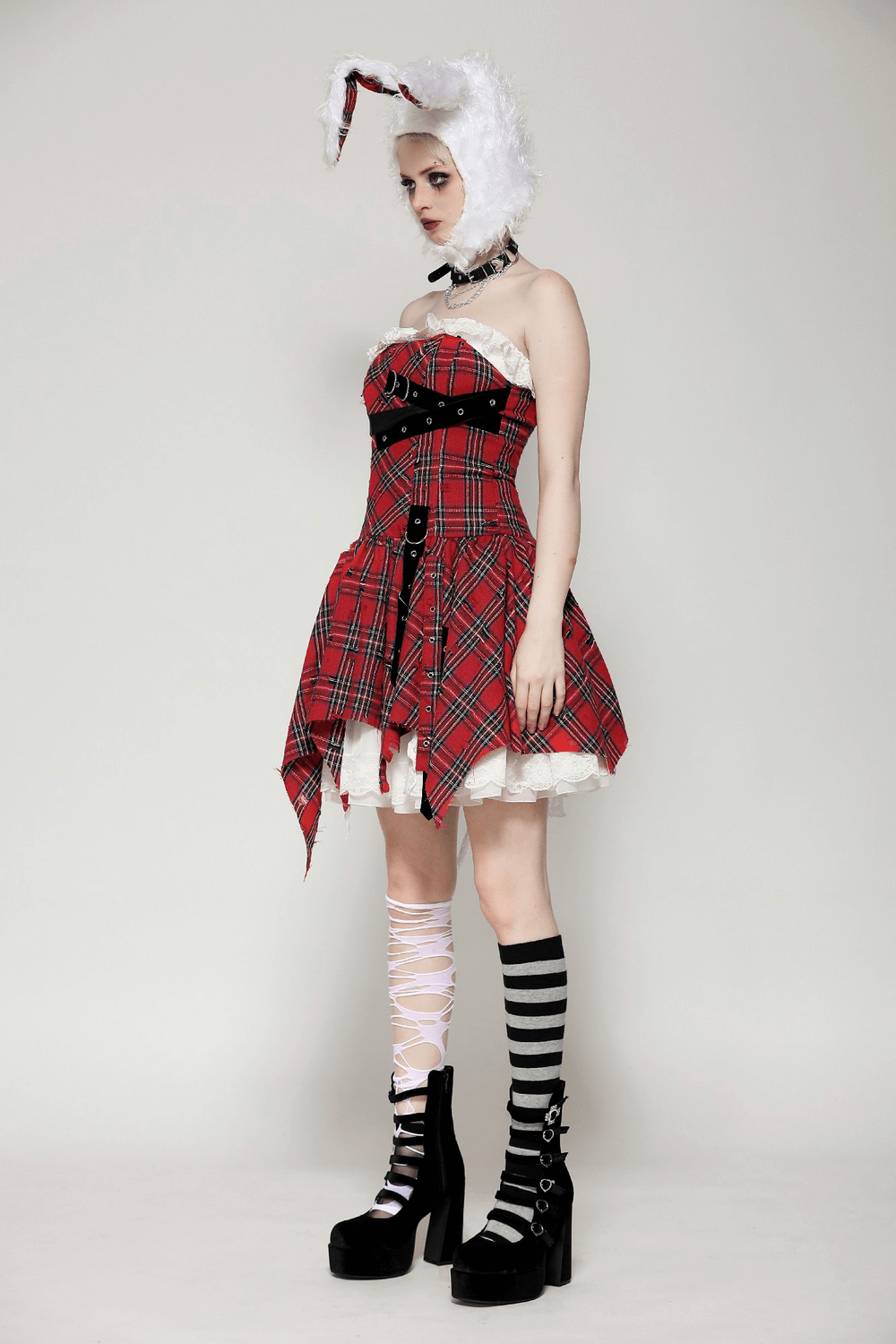 Edgy plaid corset dress with punk straps, styled with bunny accessories and platform boots, perfect for bold fashion statements.