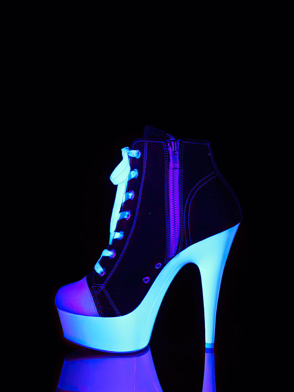 Chic Pleaser black and white lace-up stiletto heels with a striking 6-inch heel, glowing under UV light.