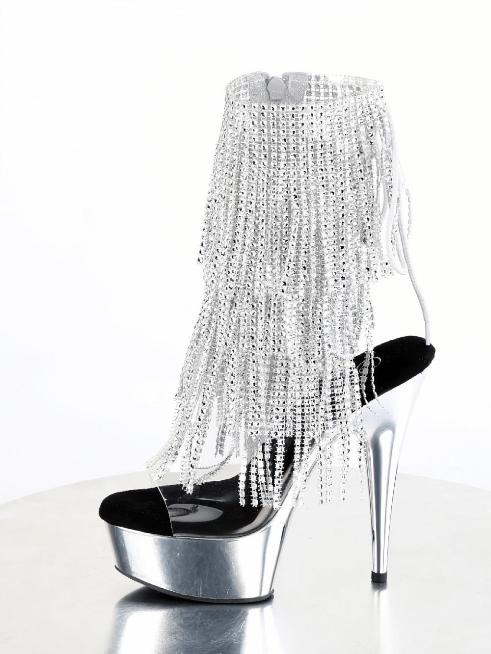 Silver rhinestone fringe stiletto heel ankle boot on a reflective surface, featuring a bold platform and open-toe design.