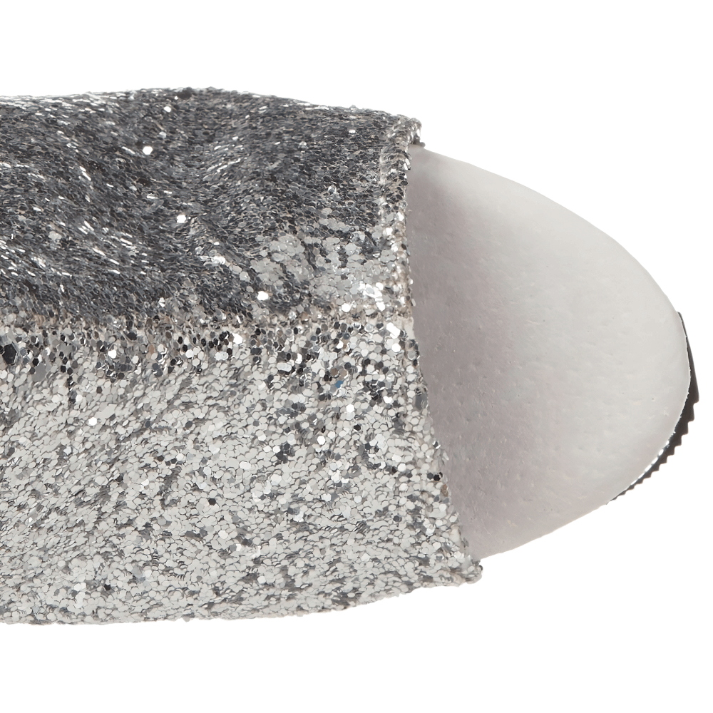 Close-up of sparkling silver glitter open-toe ankle boot, showcasing luxe texture and shine for bold style.