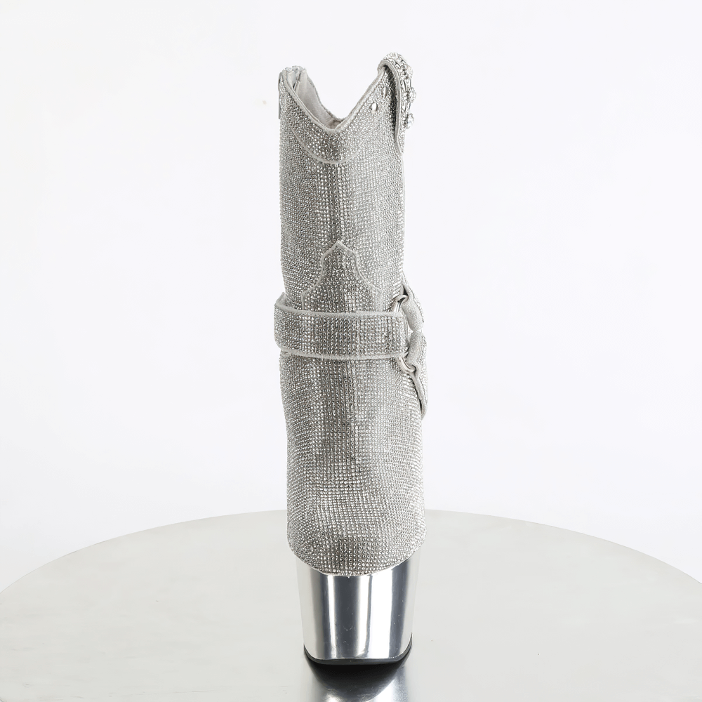 Side view of PLEASER silver rhinestone cowgirl boots with platform heels and O-ring straps on a reflective surface.