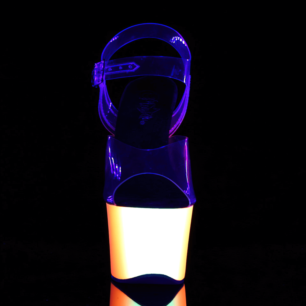 UV reactive neon platform sandals with clear straps glowing under black light.