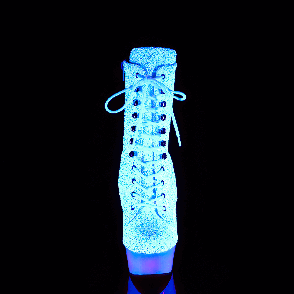 White glitter lace-up ankle boots glowing neon under blacklight with a striking heel and platform for bold style.