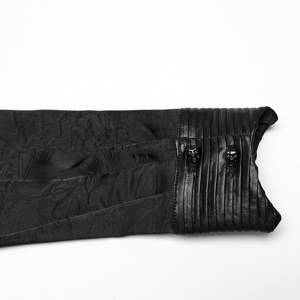 Close-up of gothic shirt sleeve with pleated texture and glossy skull button details, exuding dark elegance.