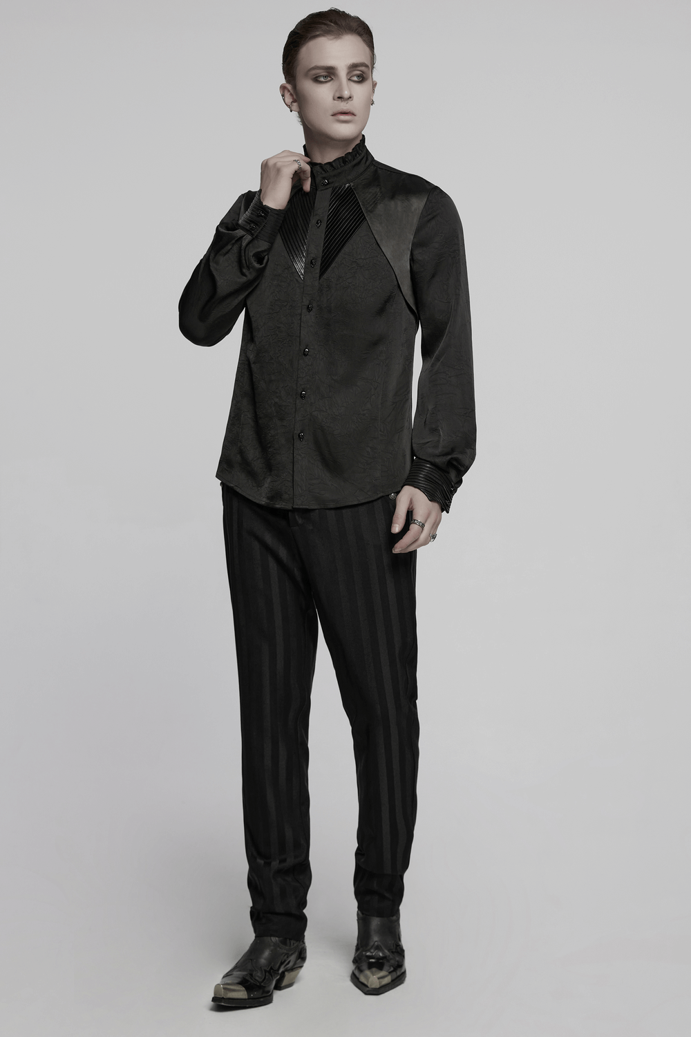 Model wearing a pleated gothic button-up shirt with glossy accents and structured design, perfect for alternative fashion.