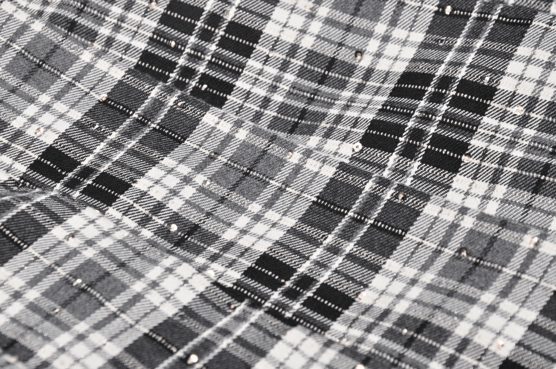 Close-up of black and white plaid fabric showcasing a classic punk-inspired texture for a gothic mini skirt.
