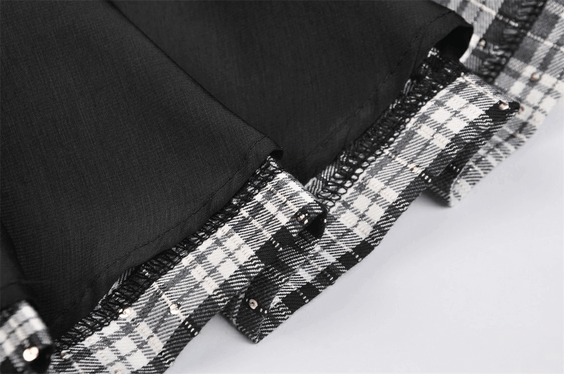 Close-up of pleated black and white plaid mini skirt showcasing edgy grunge style details.