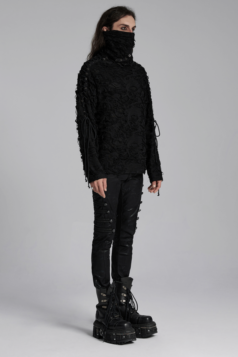 Post-apocalyptic high-neck top with distressed knit design and integrated mask, paired with edgy black pants and chunky boots.