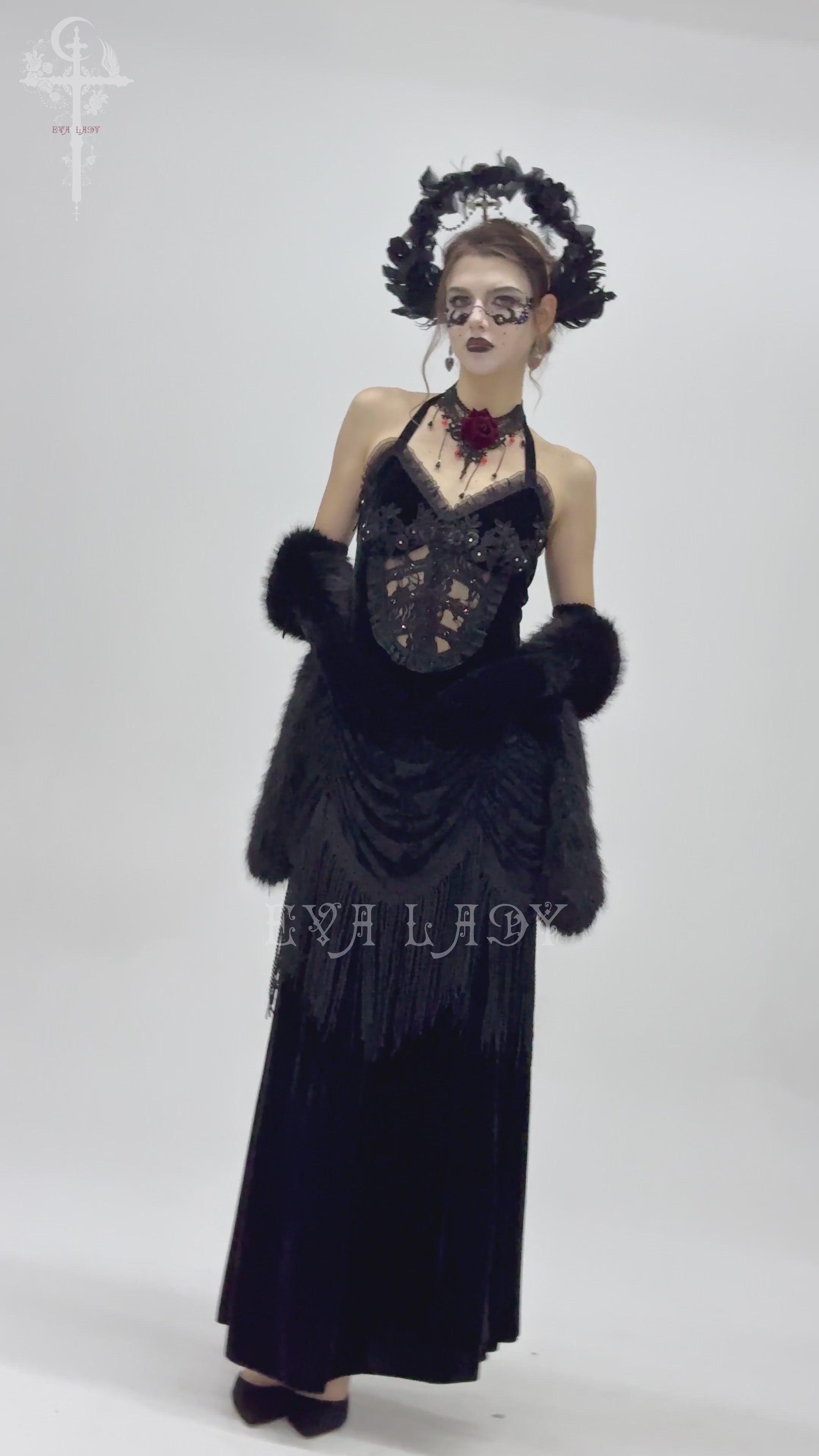 Gothic black velvet dress with lace-up back, floral accents, and fringe details, perfect for Victorian-inspired fashion.