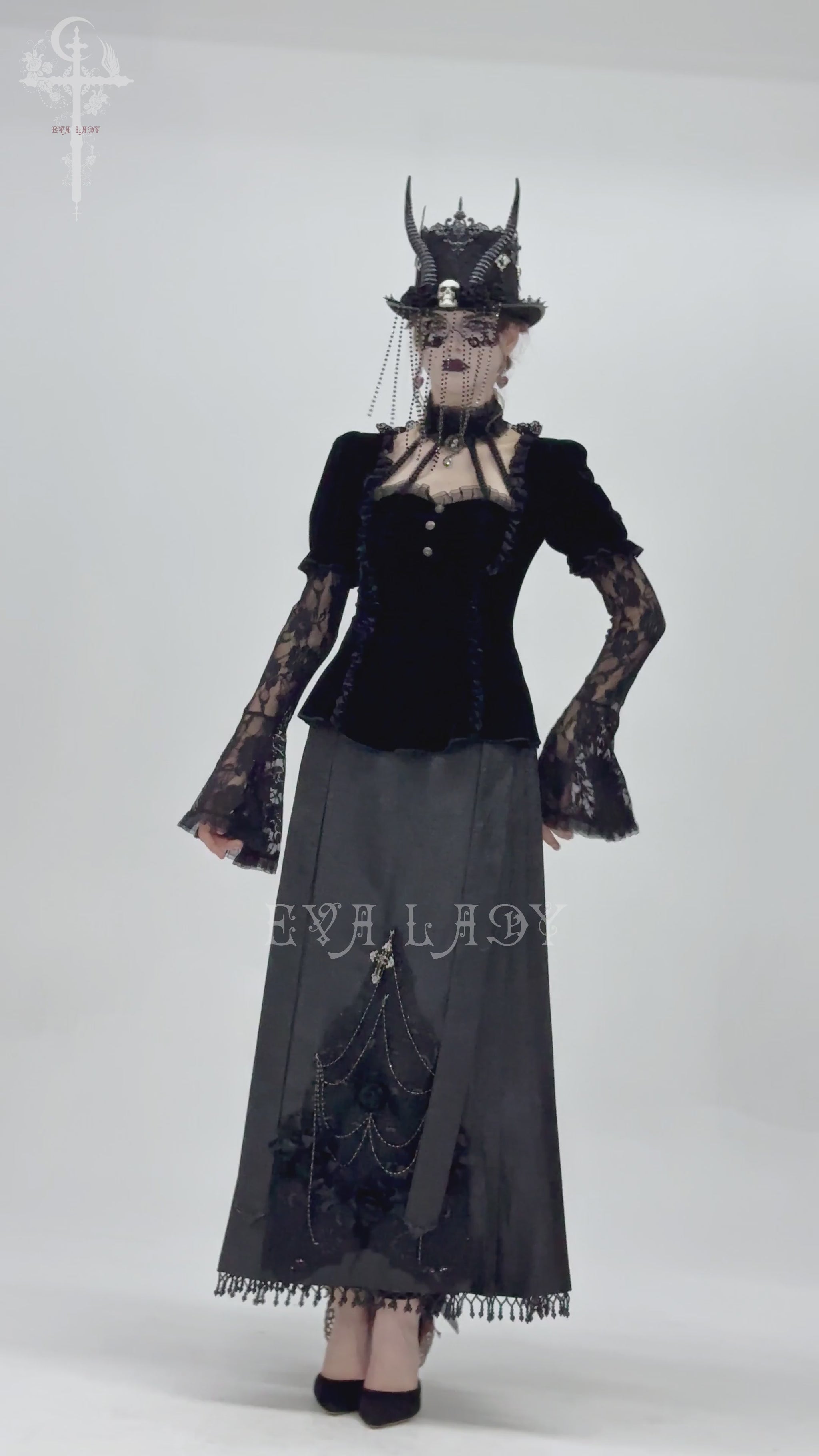 Victorian-inspired gothic outfit featuring black velvet top and lace bell sleeves, paired with a dramatic skirt and hat.