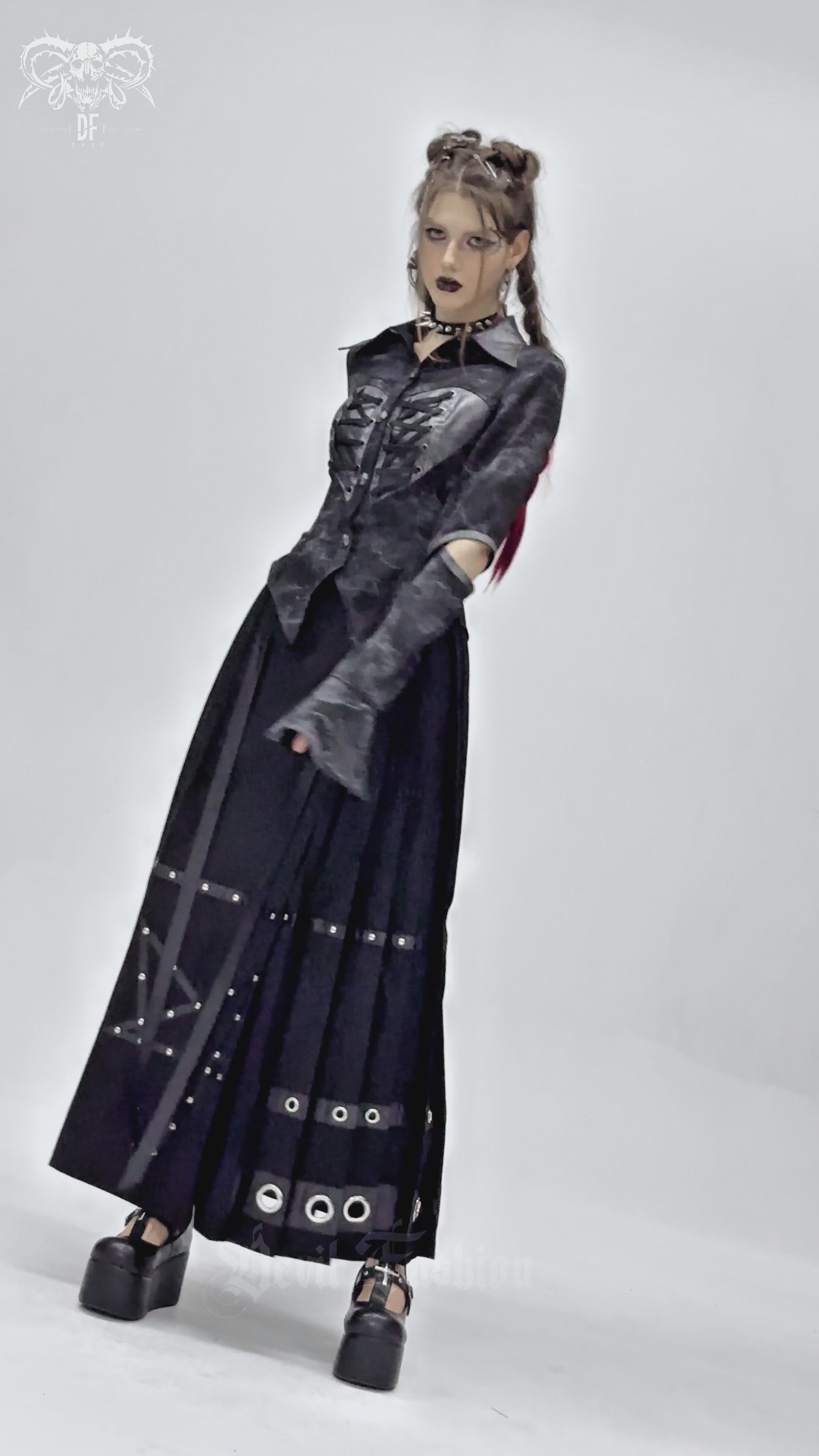 Gothic black lace-up shirt with cut-out sleeves, paired with a long black skirt for a punk-inspired look.
