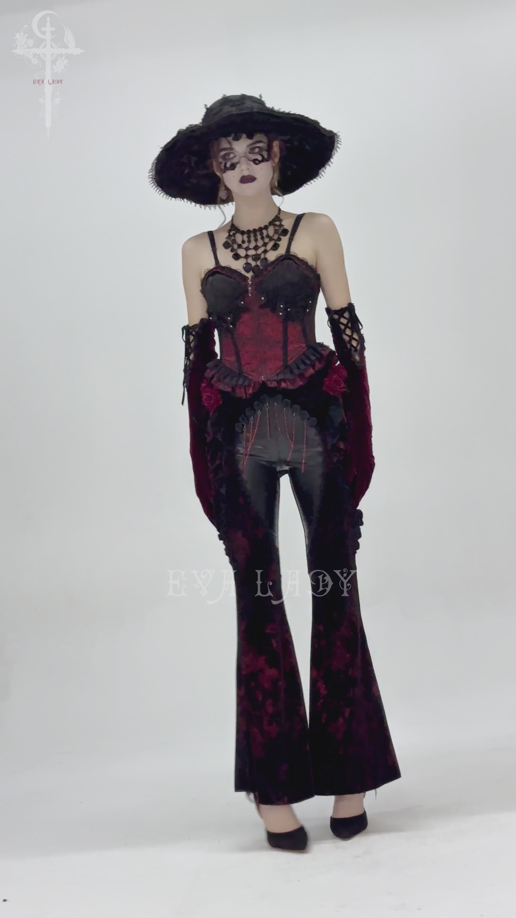Model showcasing gothic velvet flare pants with rose appliqués and leather details, epitomizing dark romantic fashion.