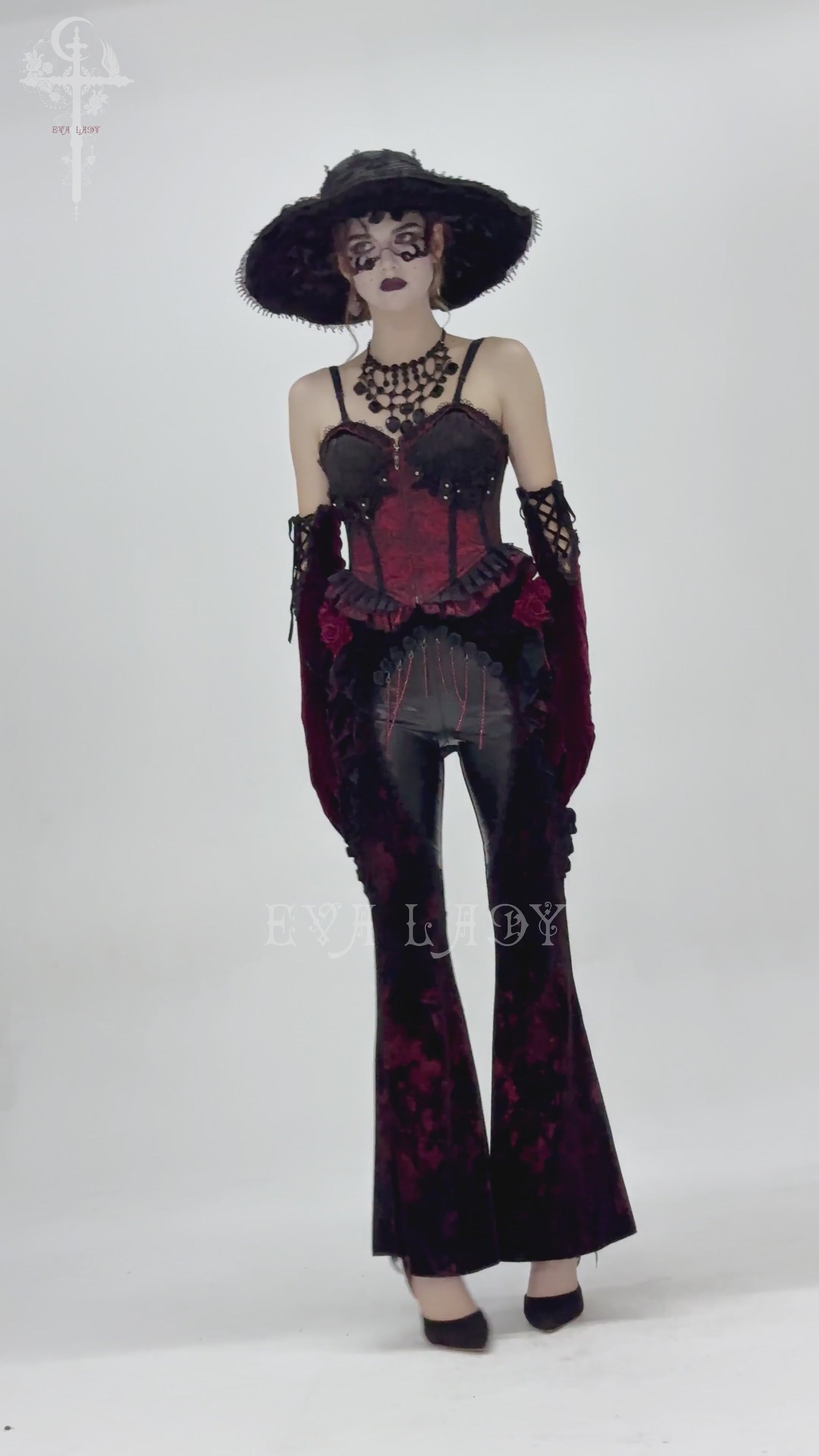 Model showcasing gothic velvet flare pants with rose appliqués and leather details, epitomizing dark romantic fashion.