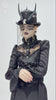Gothic black horned top hat adorned with skull, beads, and lace worn by a model in elegant dark attire.