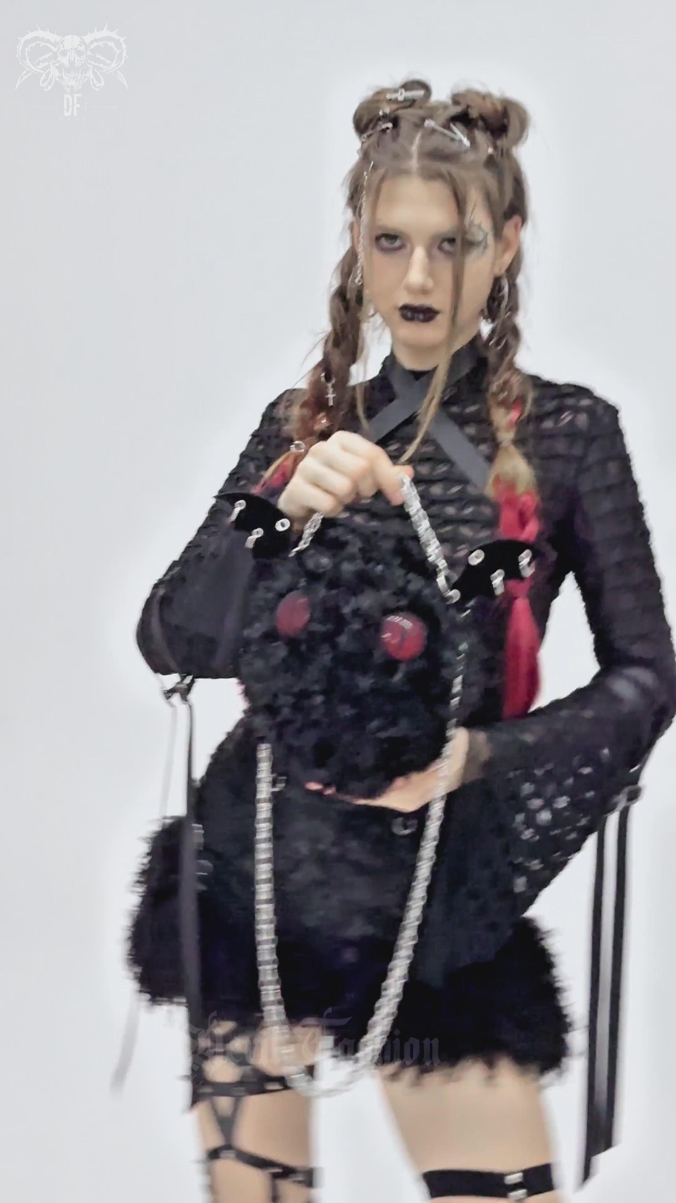 Gothic model showcasing a plush bat wing bag with red eyes, perfect for alternative fashion and spooky style.