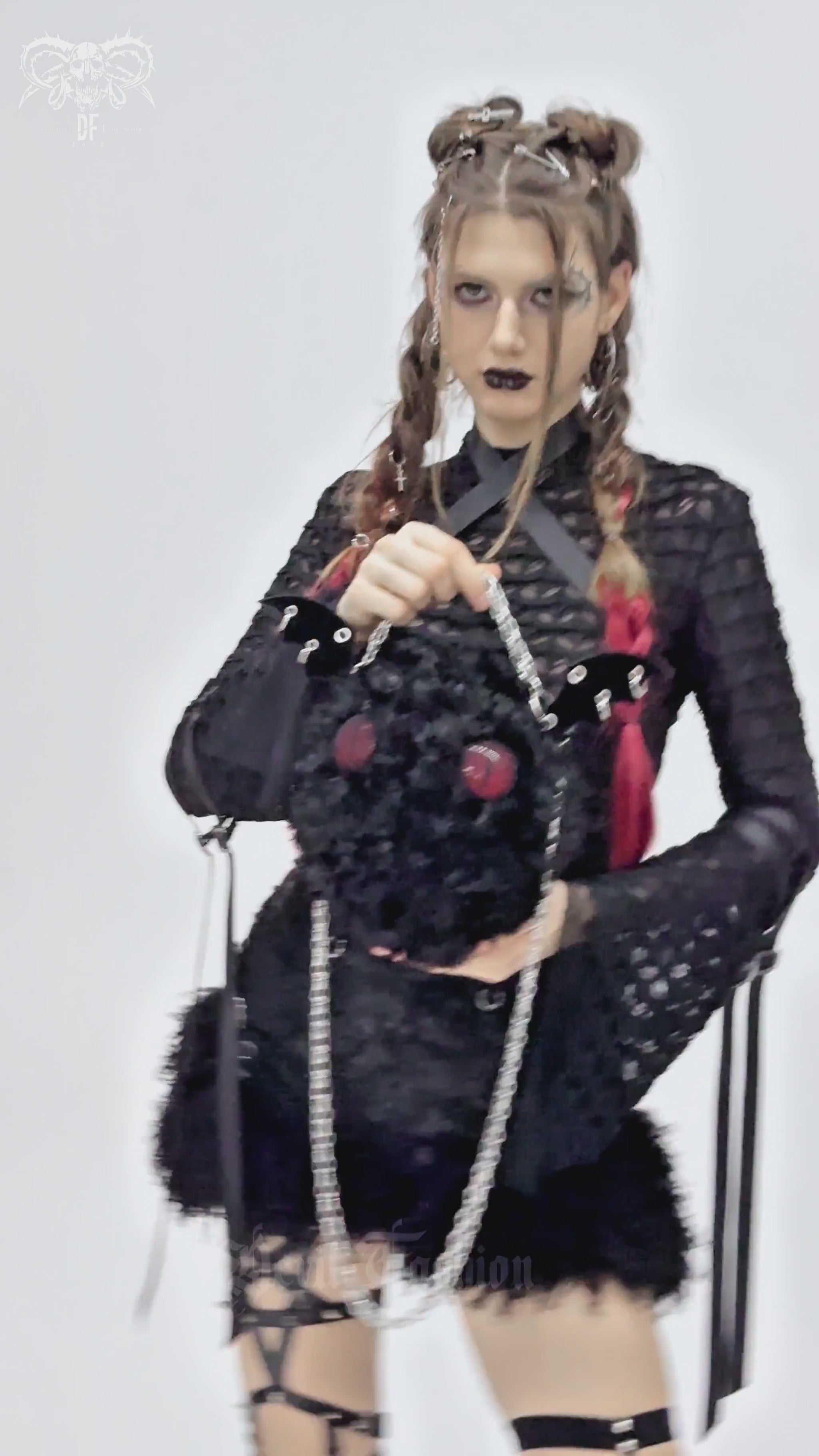 Gothic model showcasing a plush bat wing bag with red eyes, perfect for alternative fashion and spooky style.