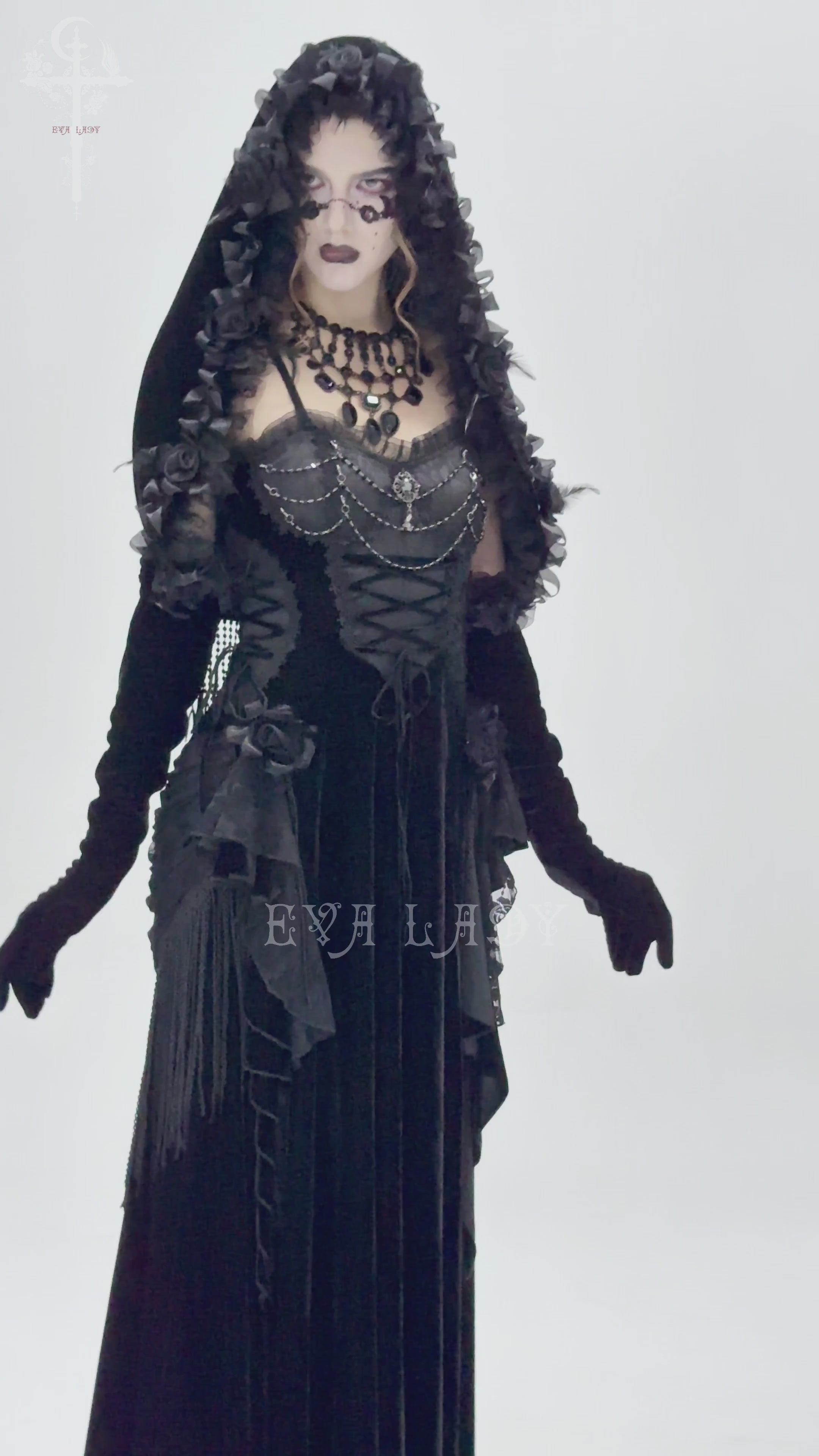 Gothic velvet hooded cape with floral detailing and fringe, evoking vintage elegance and drama.