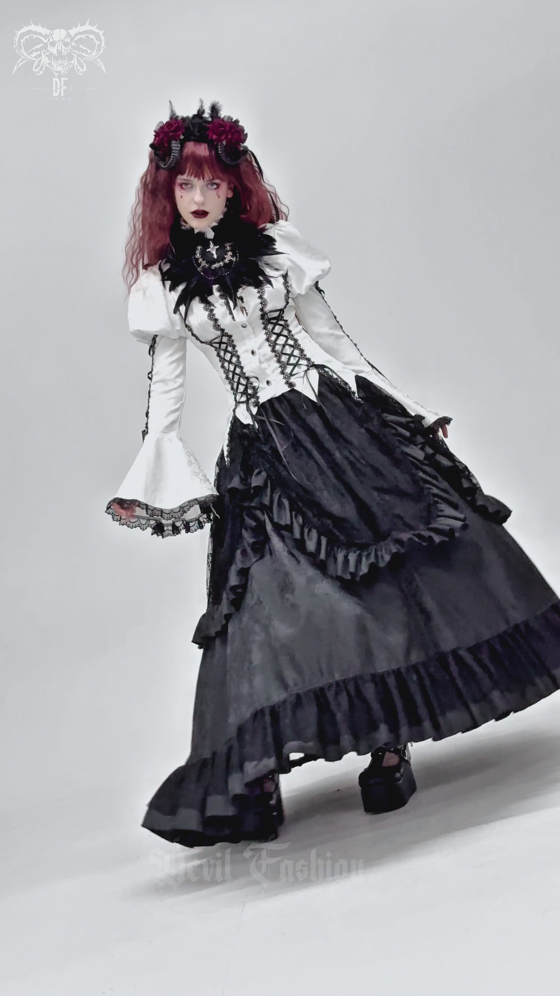 Model wearing a gothic Victorian blouse with corset ties and flared sleeves, styled with a dramatic black skirt.