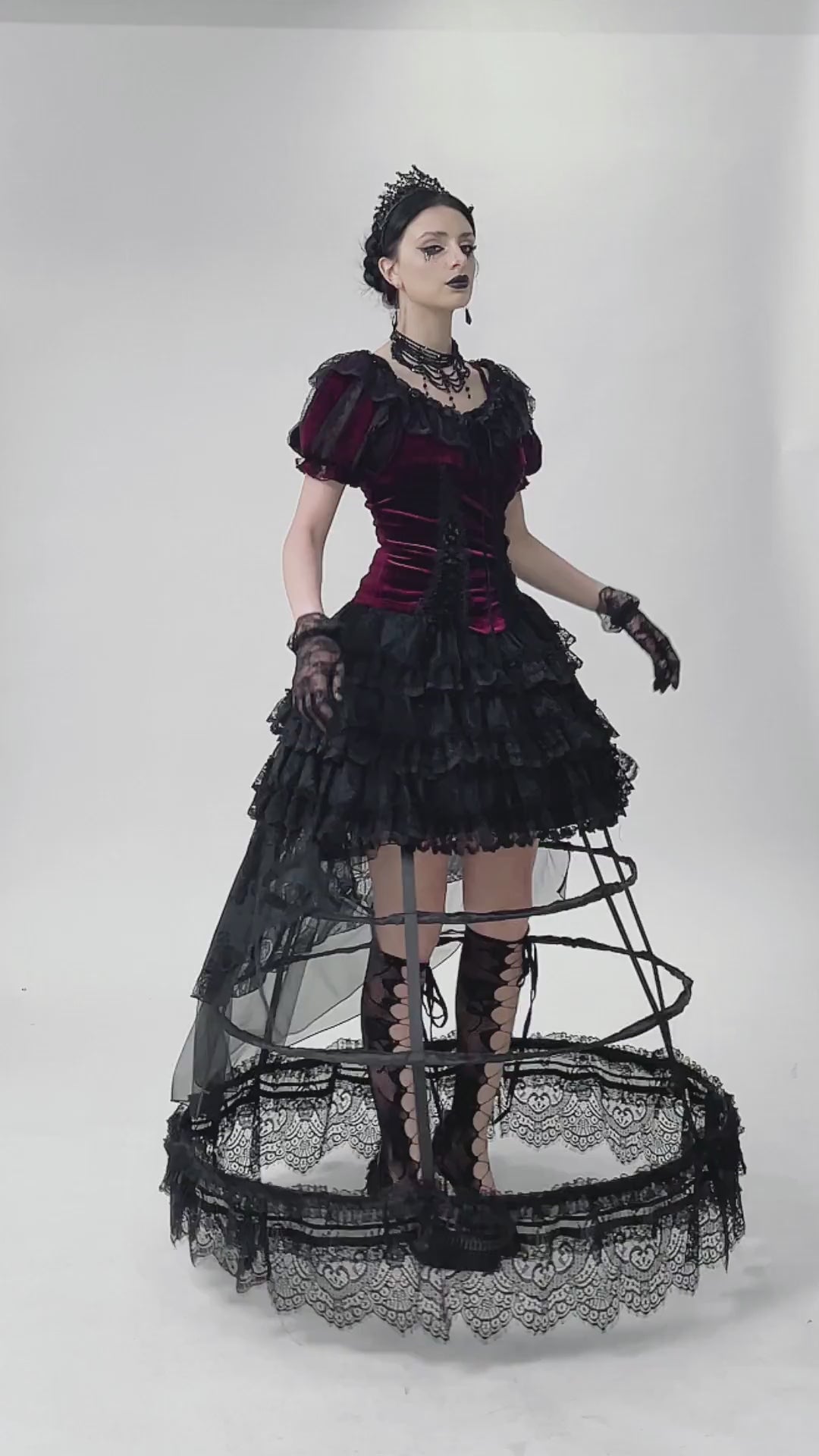 Gothic model in burgundy Victorian bolero and lace dress with ruffles and dramatic ribbon details, embodying dark romance.