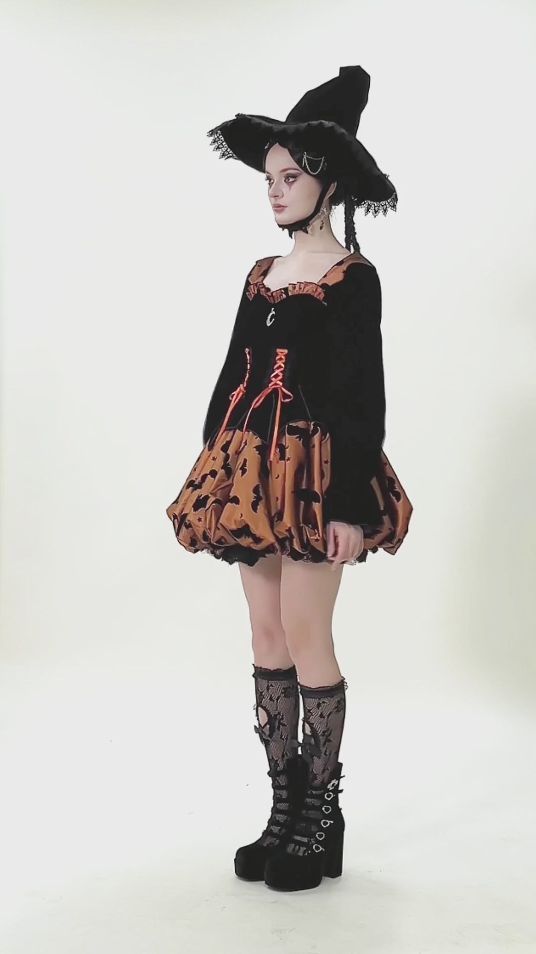 Gothic Bat Print Puff Sleeved Dress with Corset Lacing modeled with a witch hat and spooky socks.