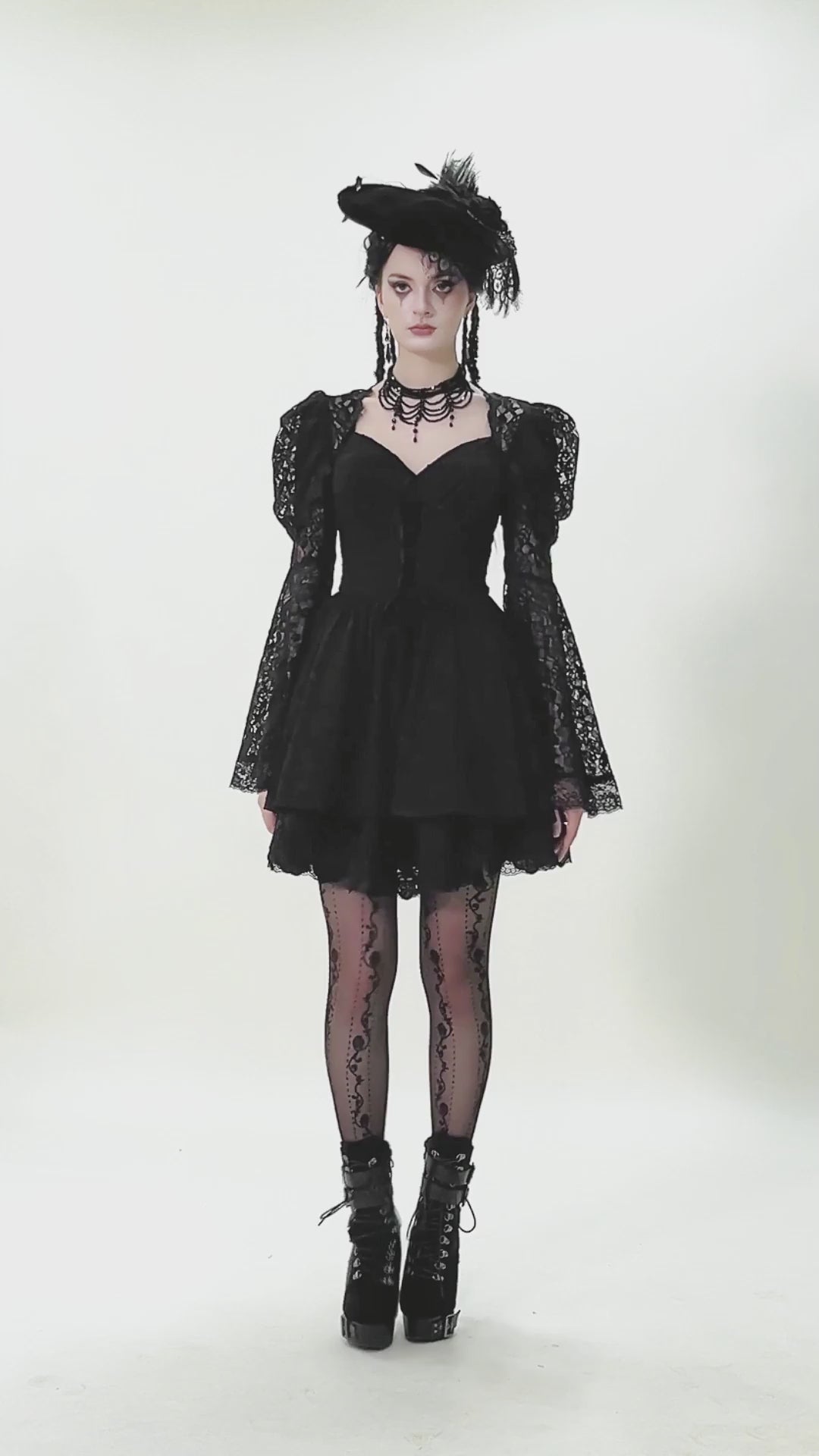 Black Lace-Up Gothic Mini Dress with Bell Sleeves worn by a model, showcasing lace details and flared sleeves.