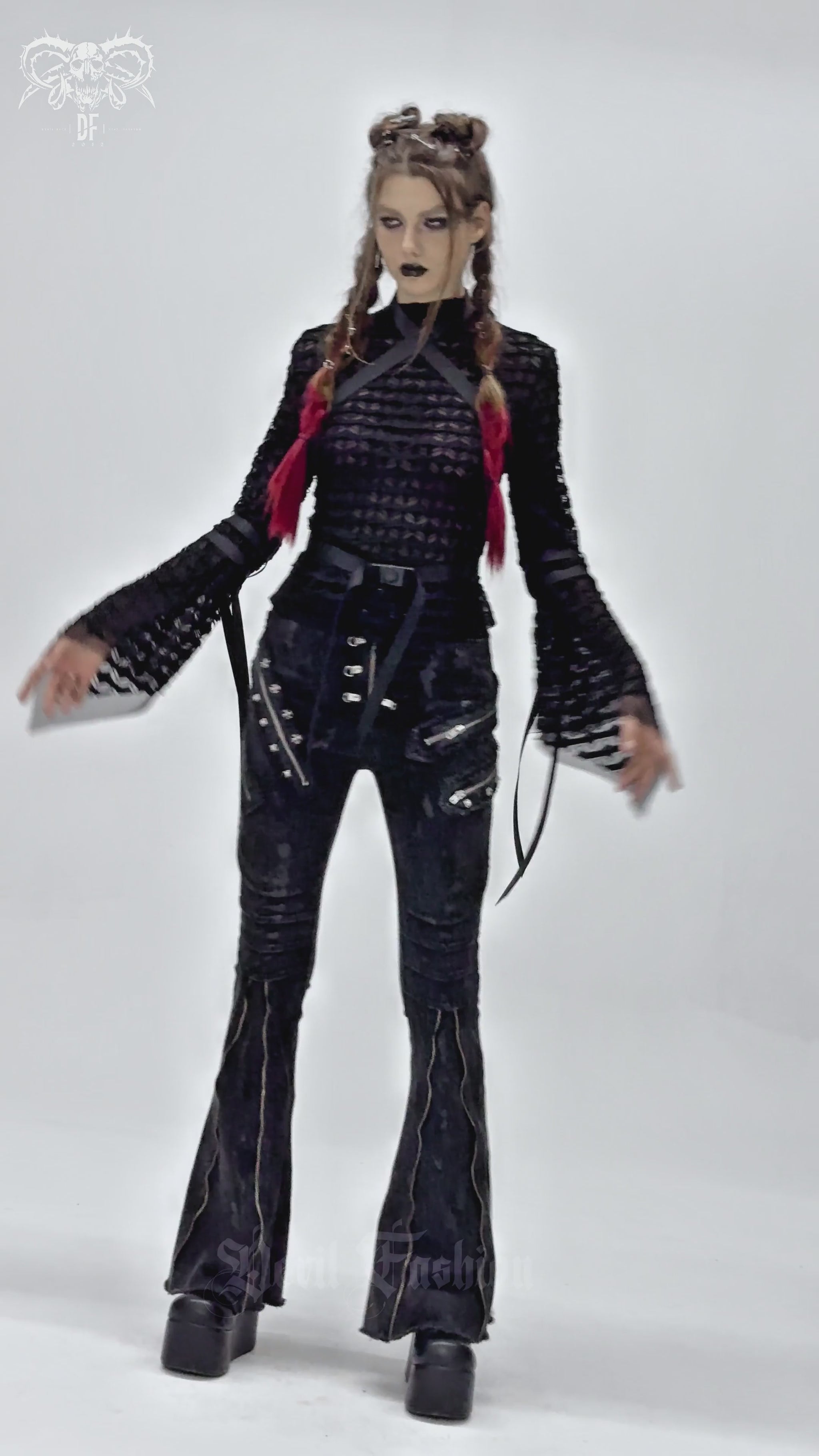 Gothic lace sheer top with straps and flared sleeves styled with black flared trousers and platform boots.