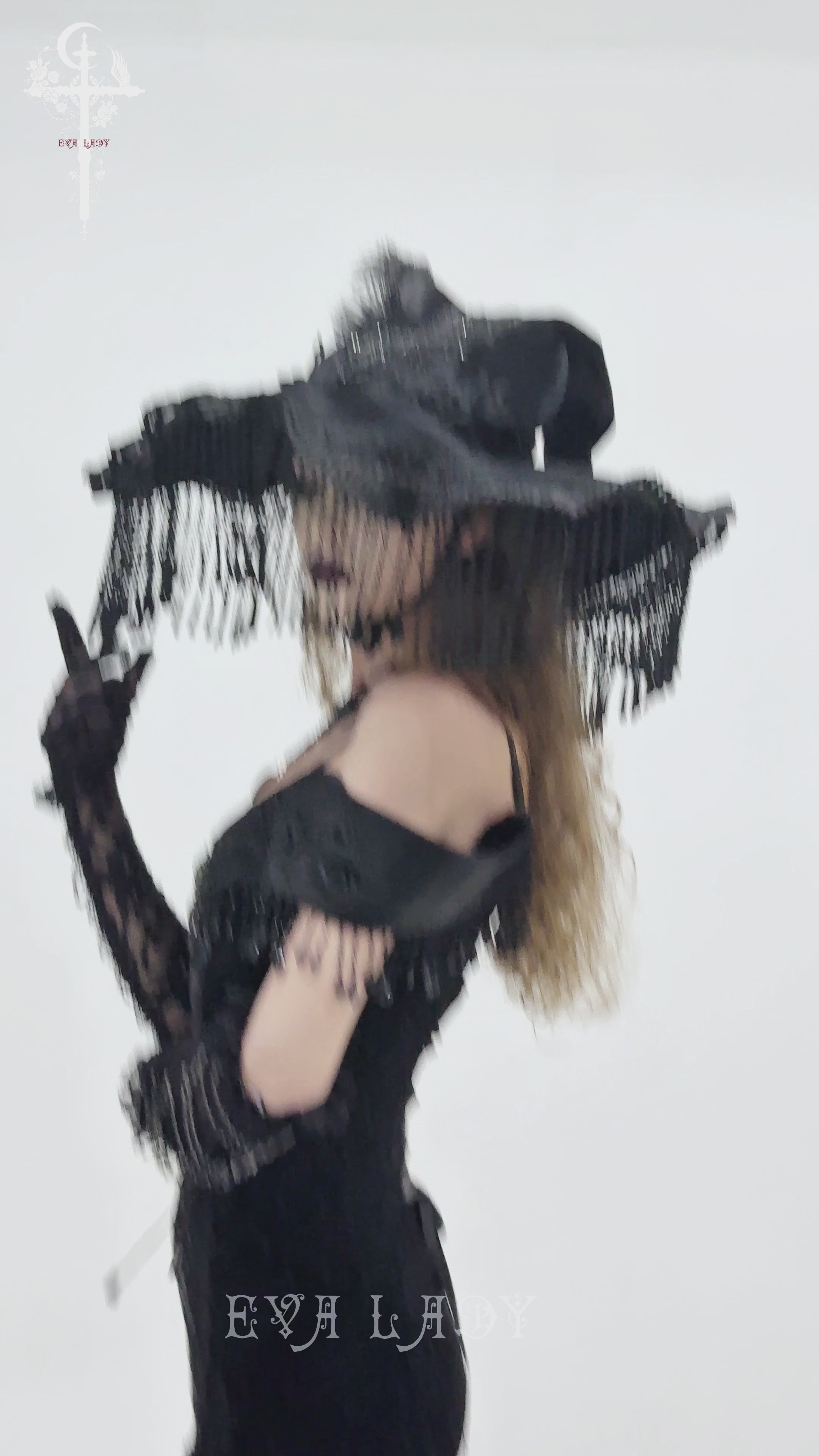 Black Witch Hat with Lace Fringe and Feather Detail worn by a model in a gothic costume.
