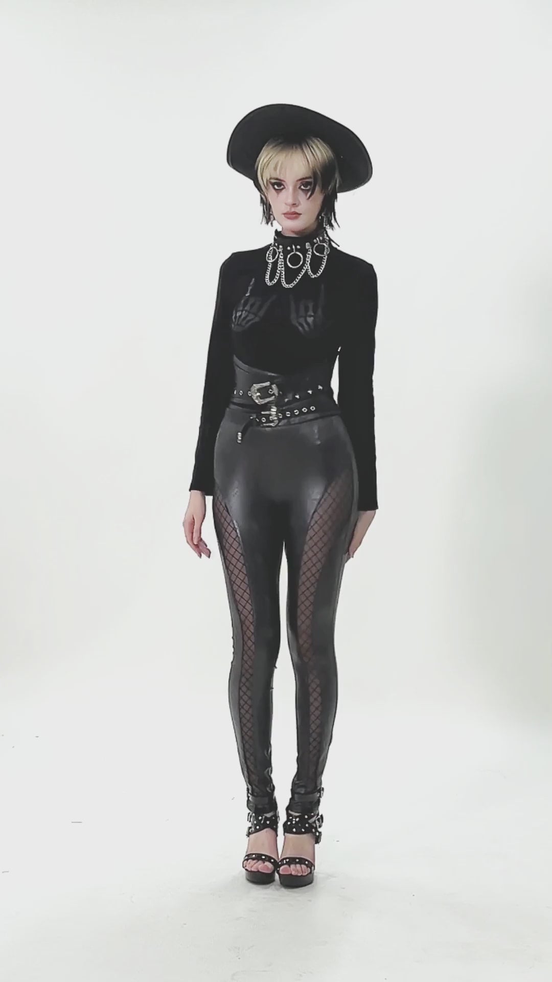 Model showcasing Gothic Faux Leather and Mesh Panel High-Waist Skinny Pants with punk accessories and bold style.