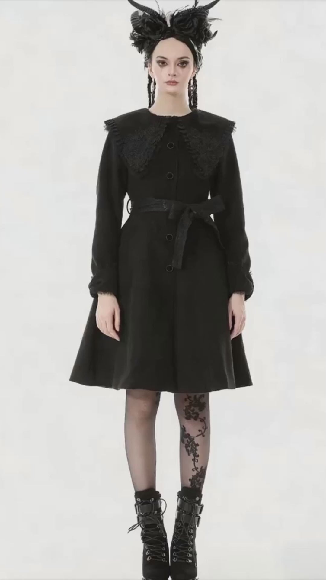 Gothic Black Coat with Lace Collar and Bow Detail worn by a model, featuring an embroidered collar and dramatic flared silhouette.