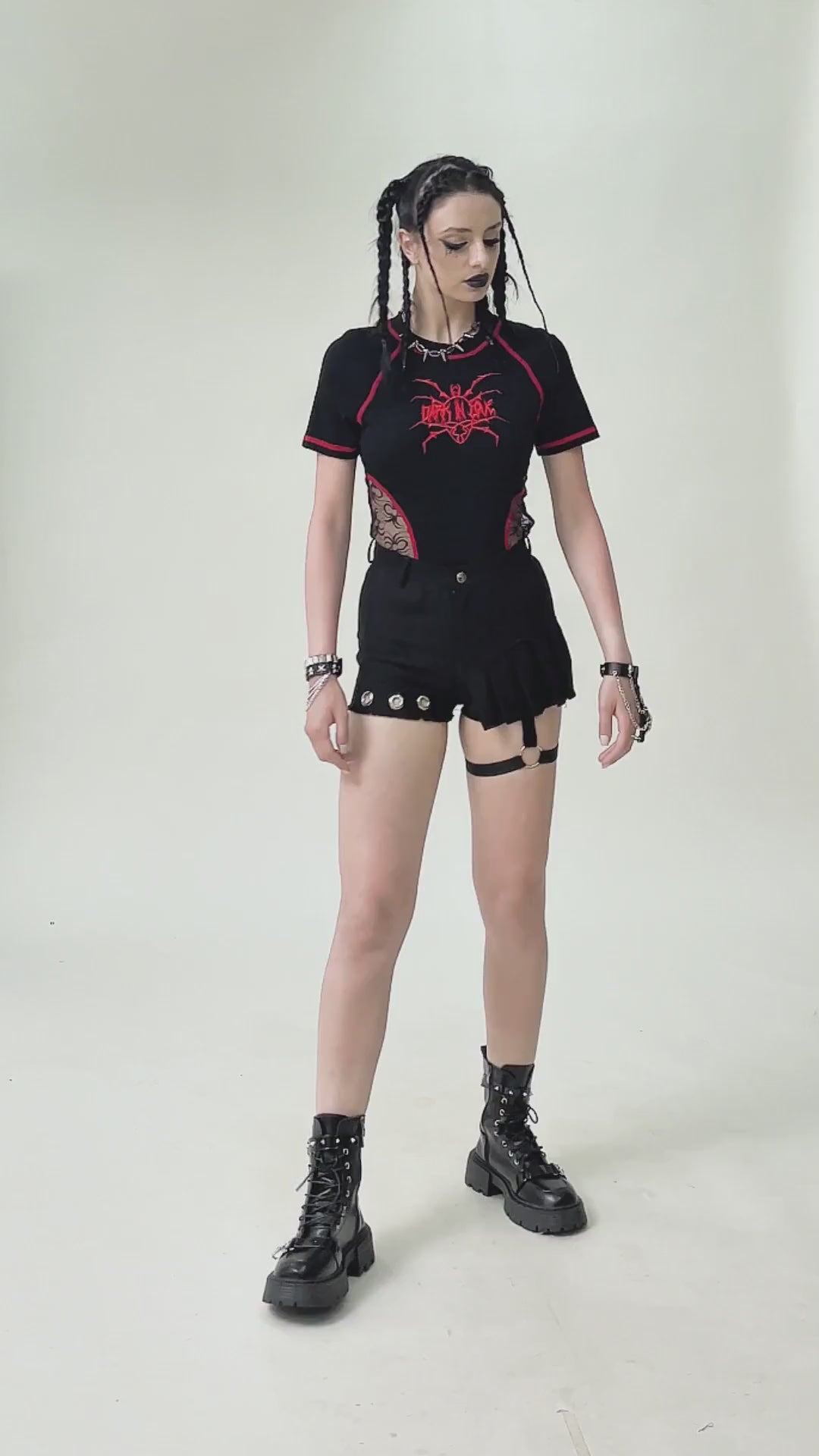Alternative punk fashion: model wears sexy pleated shorts with O-ring strap and eyelet details, showcasing a rebellious style.