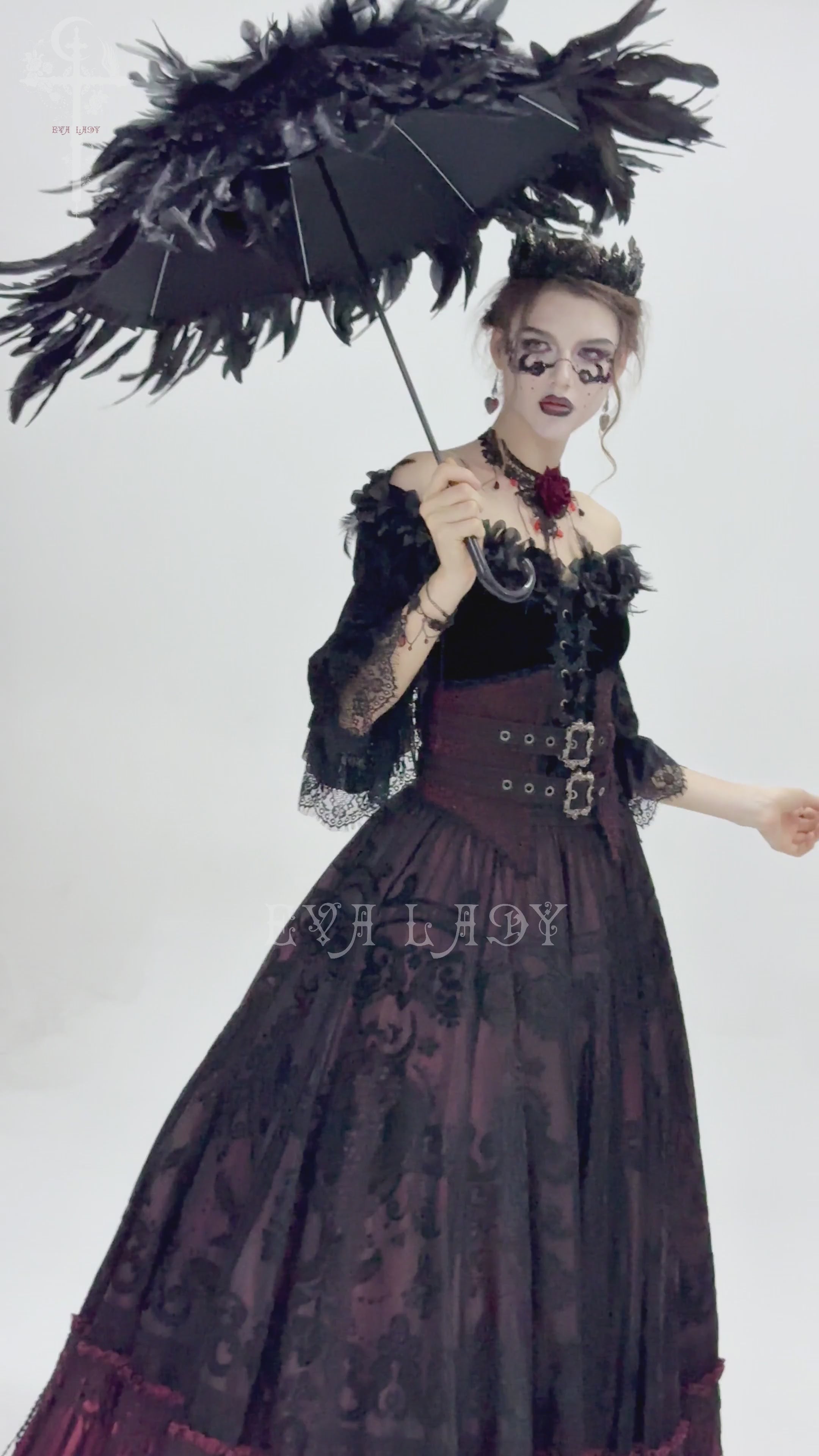 Elegant goth woman in black feathered umbrella and Victorian dress, showcasing dark fashion style.